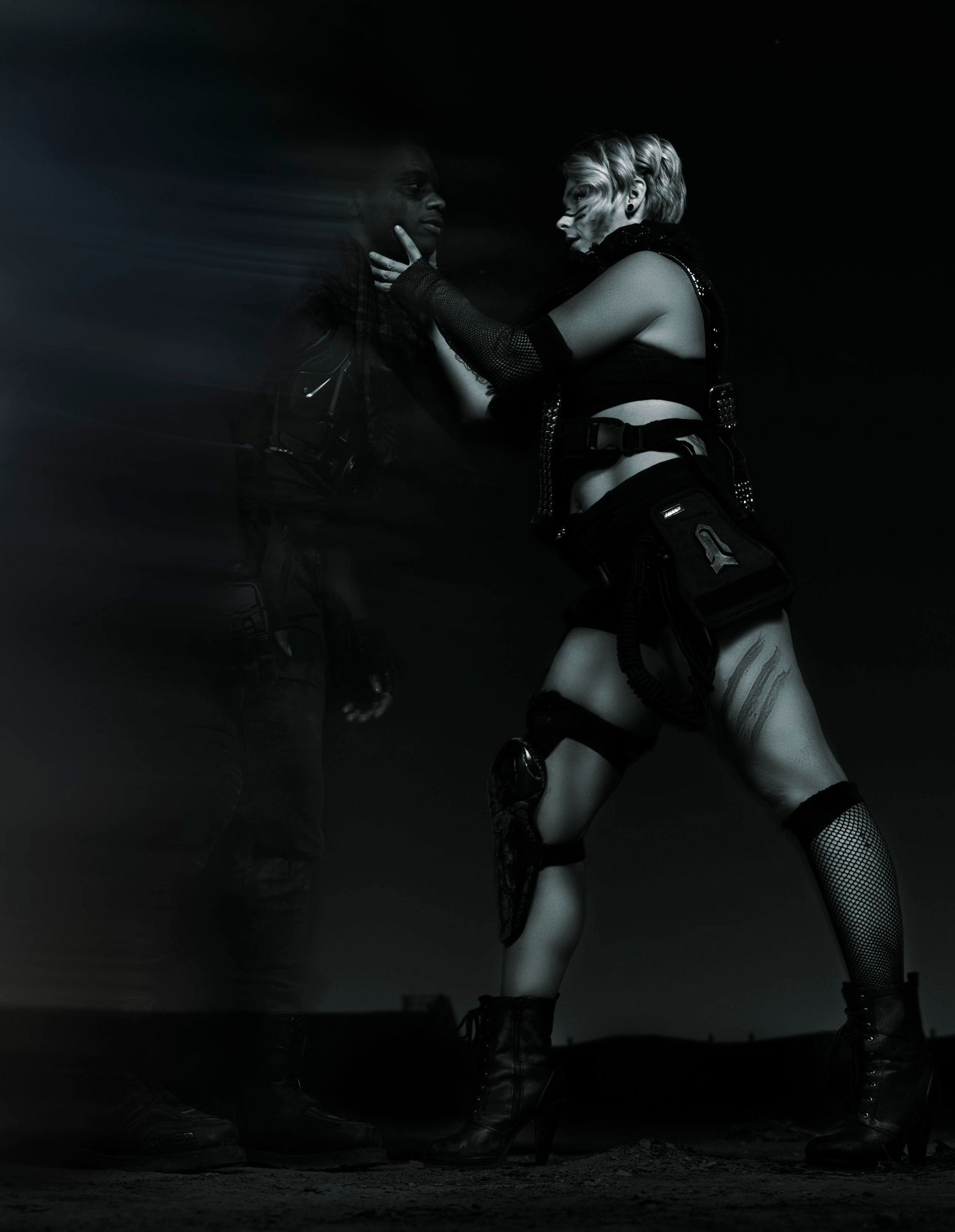Dramatic black and white performance photo showing dancers in theatrical costumes and poses.