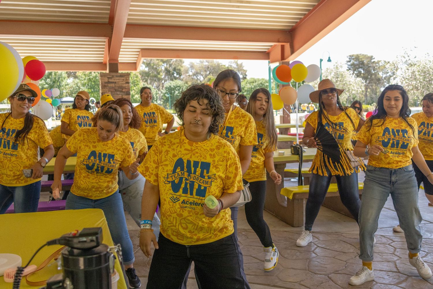 Group celebration with coordinated dance moves performed by team members in bright yellow uniforms.