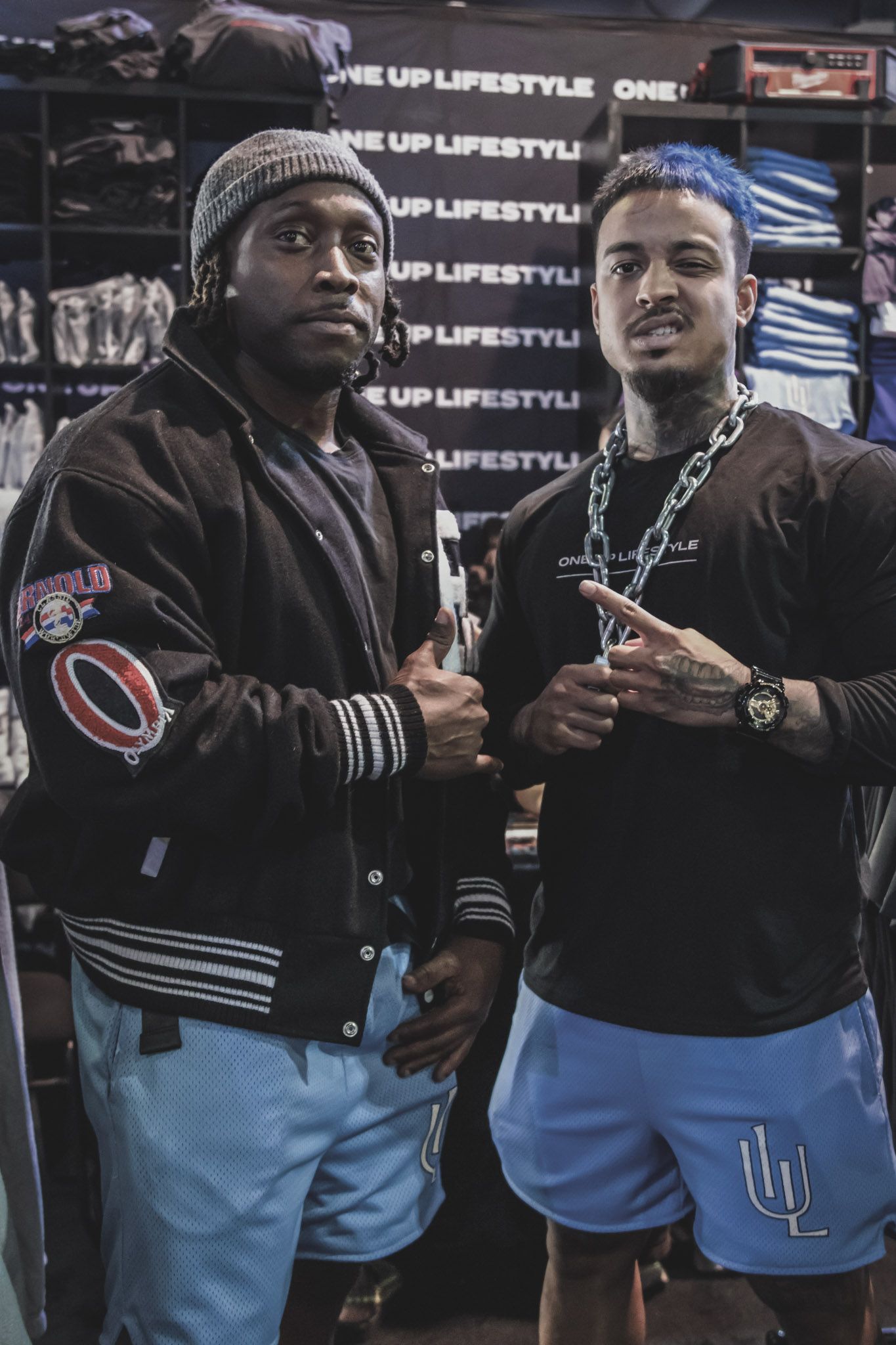 A group of performers wearing matching black hoodies and light blue pants stand together at an event.