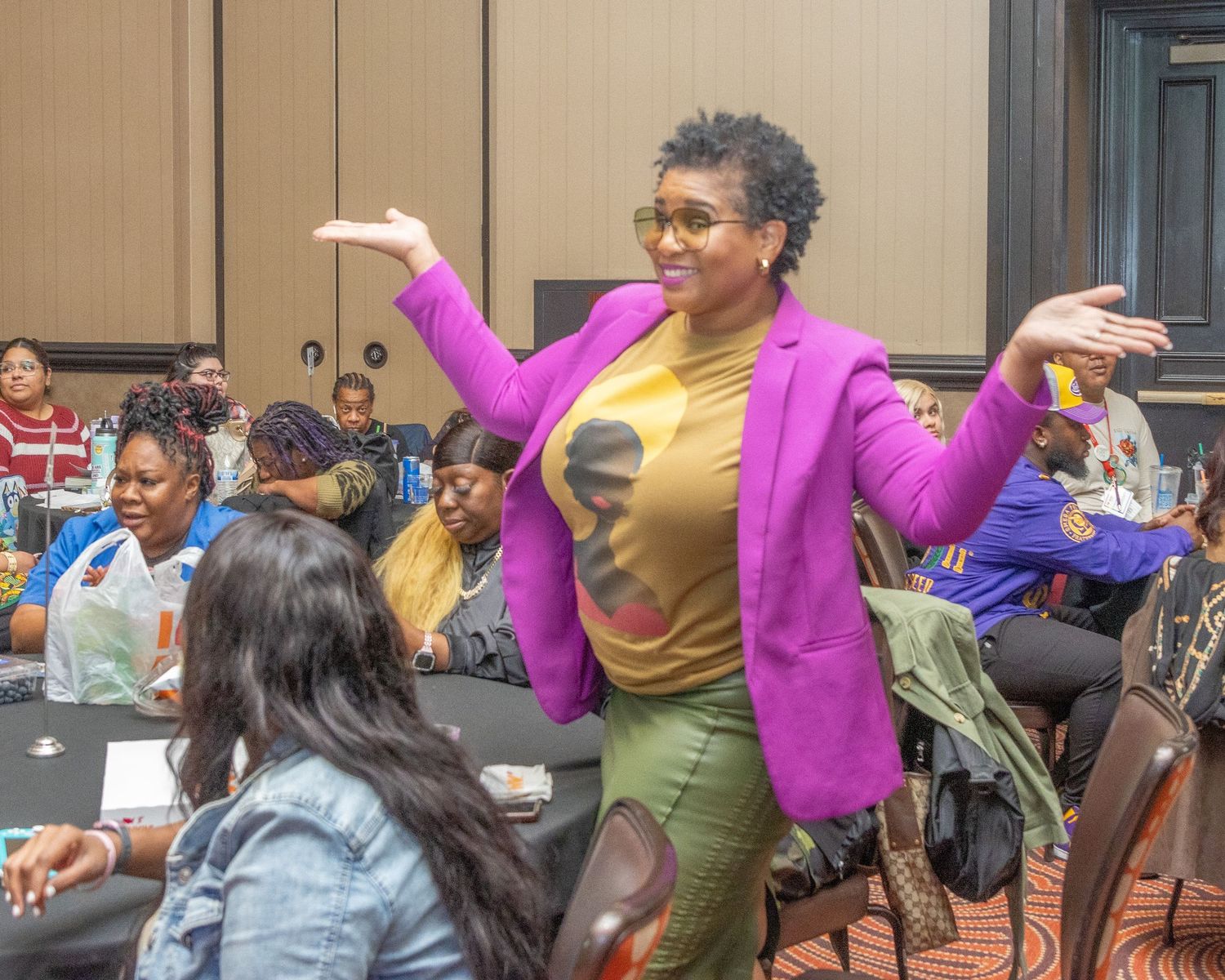 People in bright pink and casual attire socializing at an indoor event.