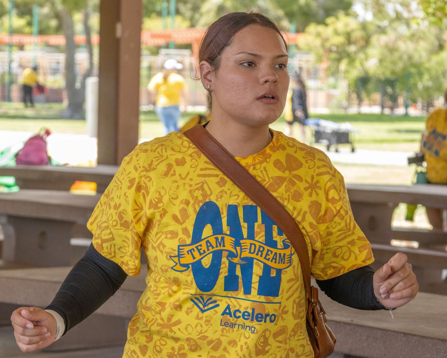 Team member in yellow patterned shirt and jeans participating in group activity.