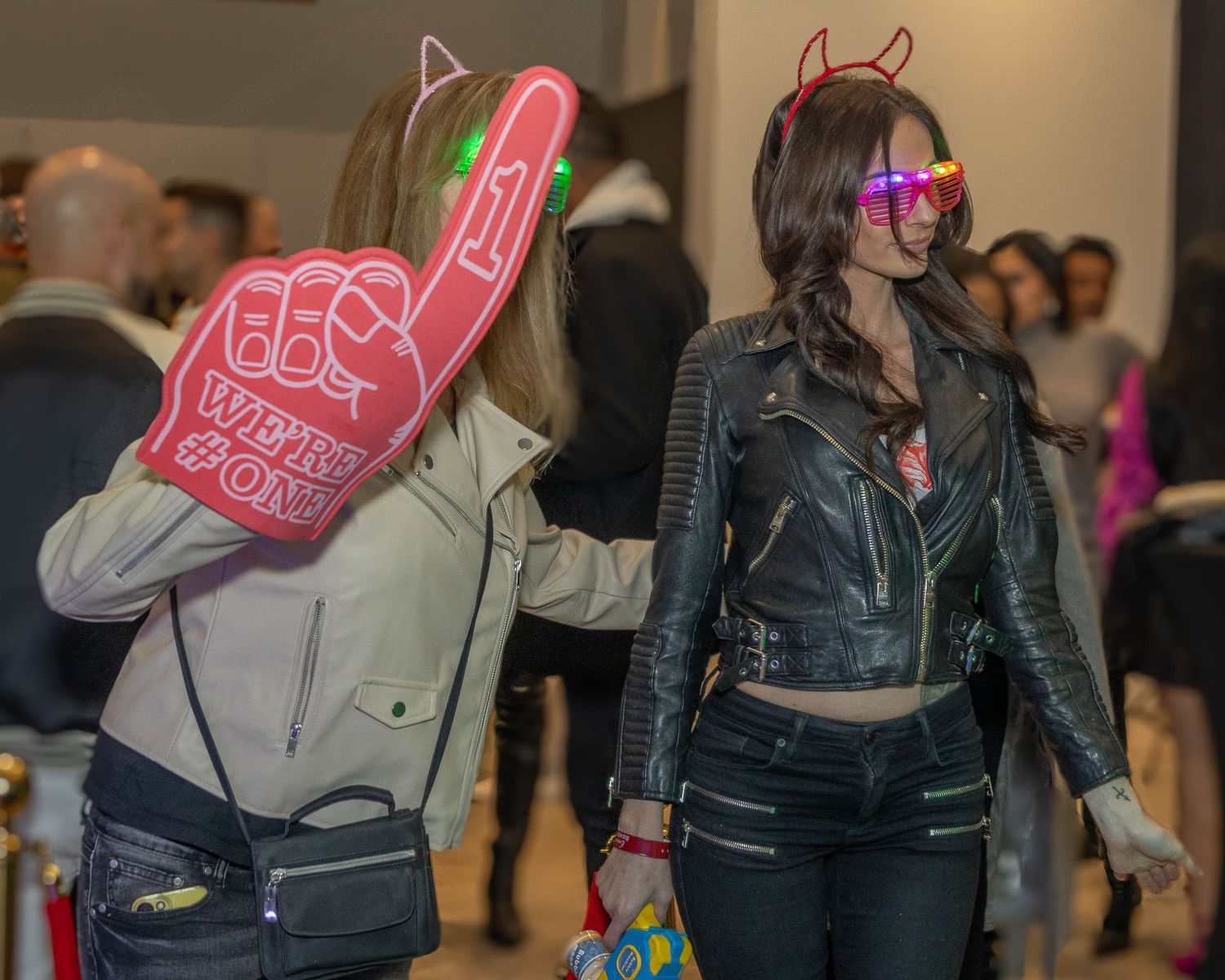 Attendees in leather jackets and casual wear interacting at an indoor event.