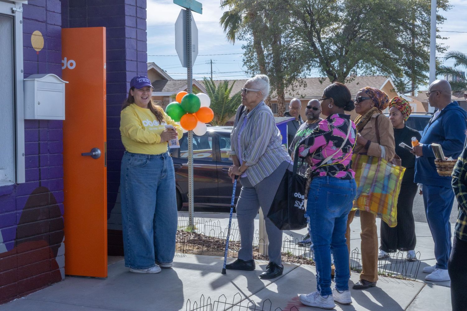 People waiting in long outdoor lines at a business entrance while practicing social distancing in masks.