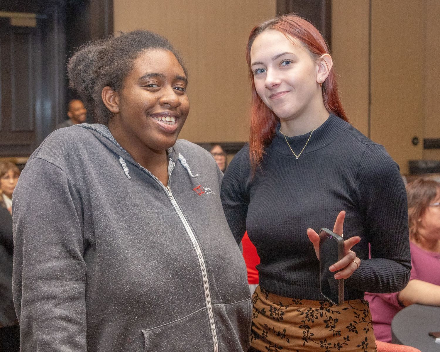 Two people share an animated conversation during an indoor social gathering.