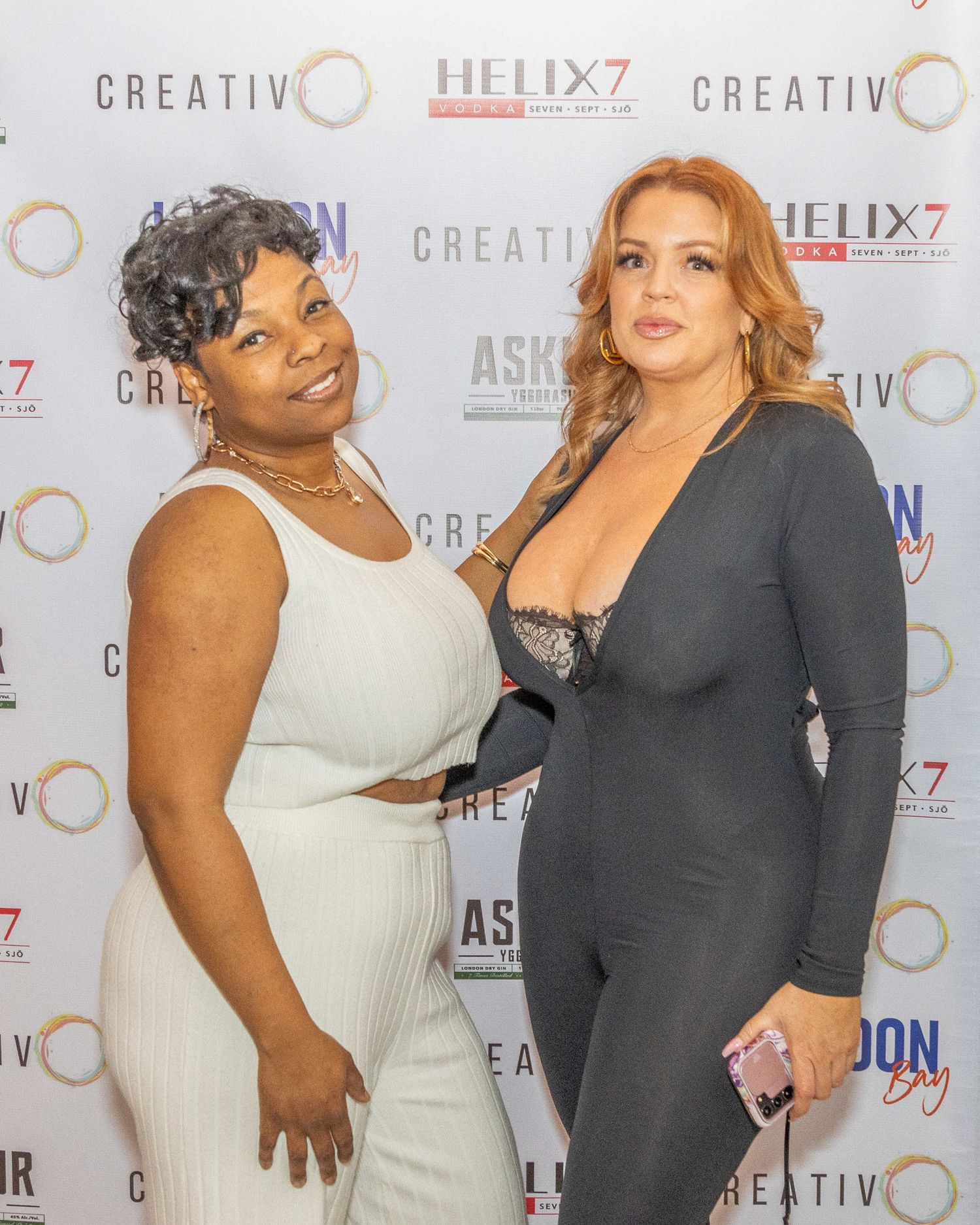 A step sequence of people posing together against a branded backdrop at a red carpet event.