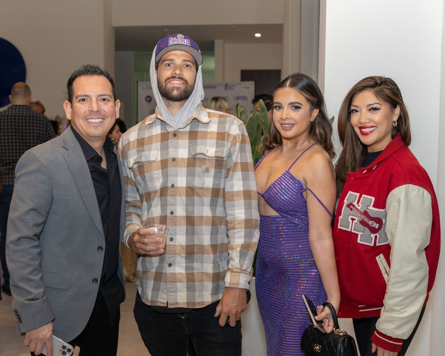Group of attendees posing together at a social event in a modern interior space.
