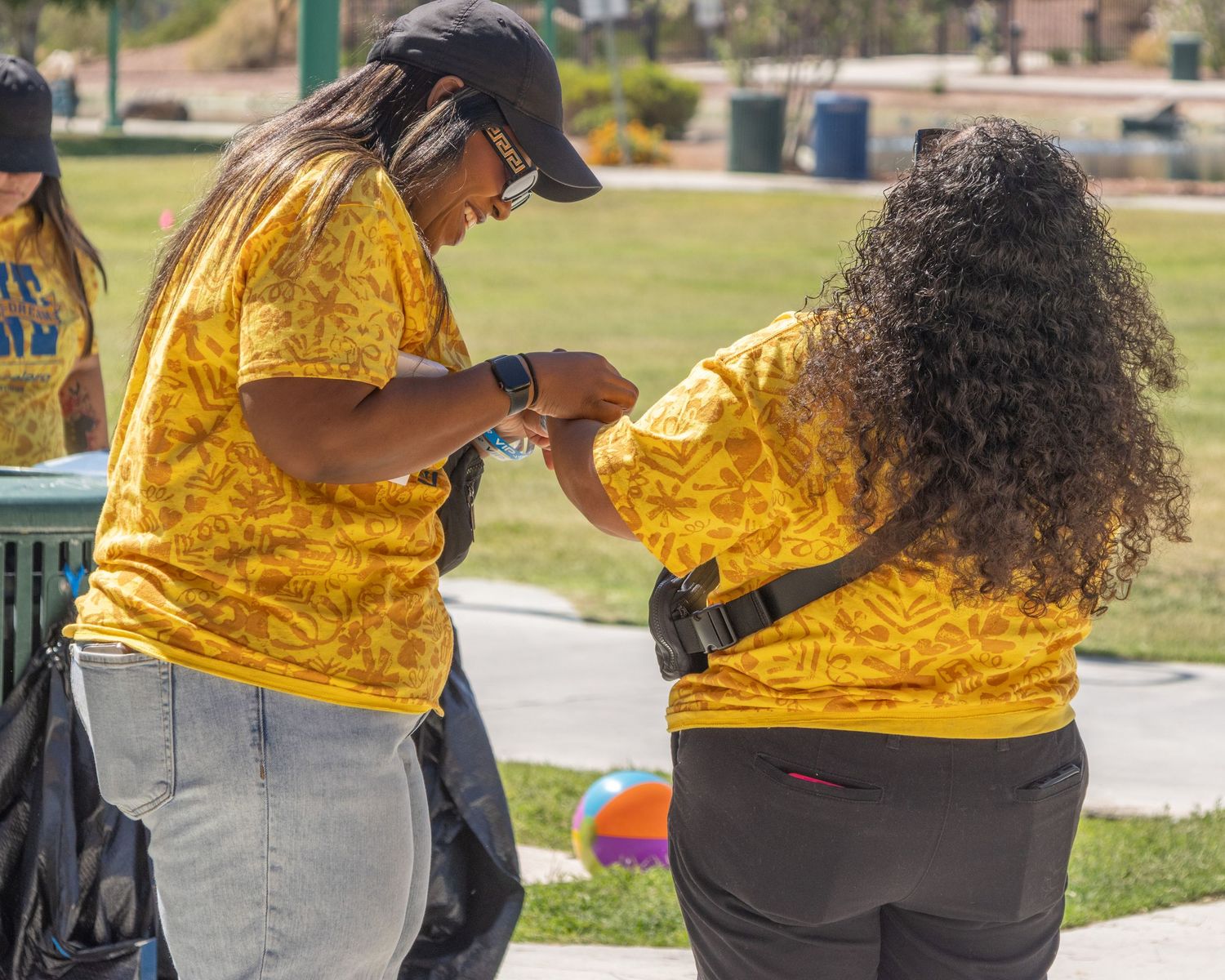 Event staff wearing yellow shirts organizing activities at an outdoor station.