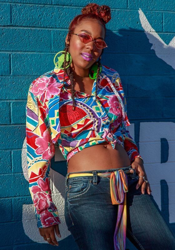 Colorful fashion photography against a bright turquoise wall showcasing vibrant patterned clothing and accessories.