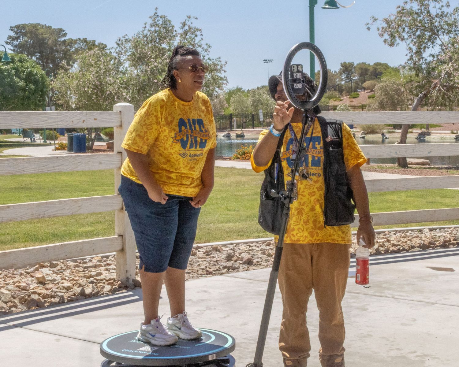 People in matching attire gathering around exercise equipment at an outdoor park.