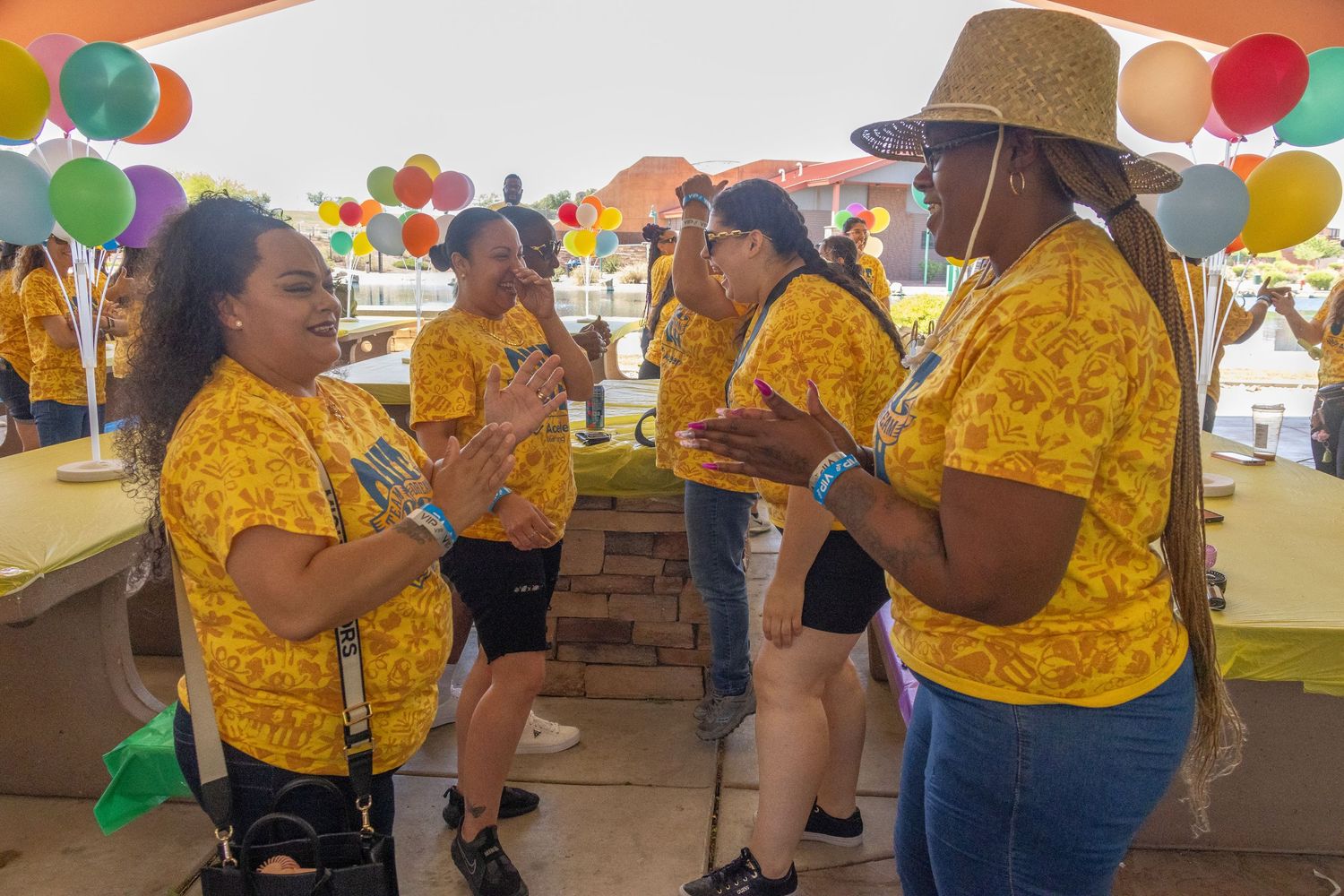 Group event with colorful balloons and decorations featuring participants in yellow shirts.