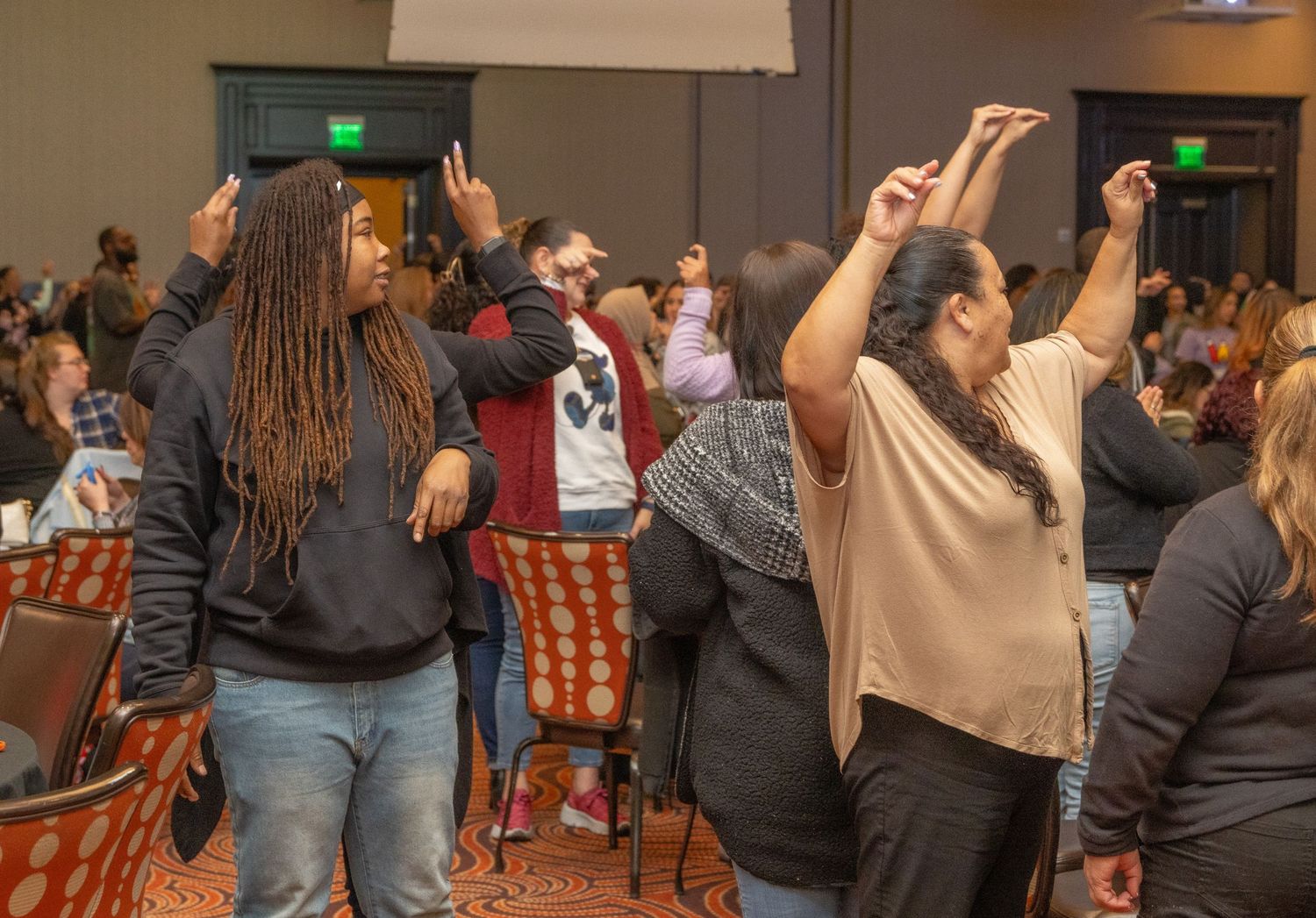 Crowd engaged in lively dancing and movement at indoor event.