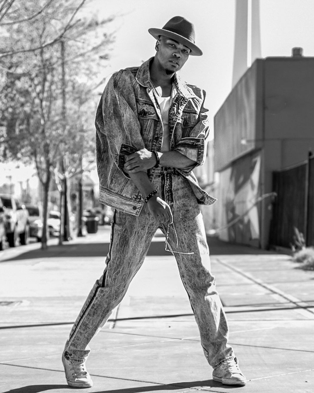 A series of black and white photos showing a person breakdancing on pavement, capturing dynamic street dance moves.