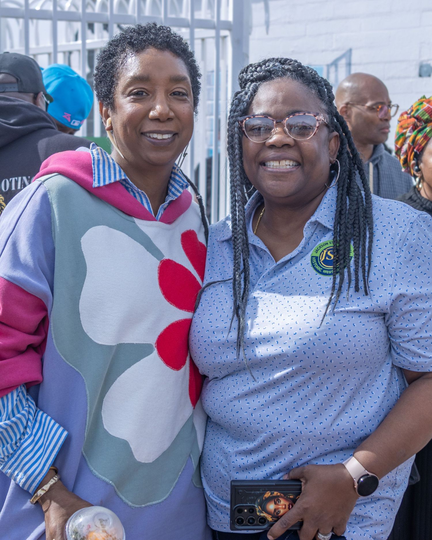 Group of smiling people embracing and posing together at a casual gathering event.