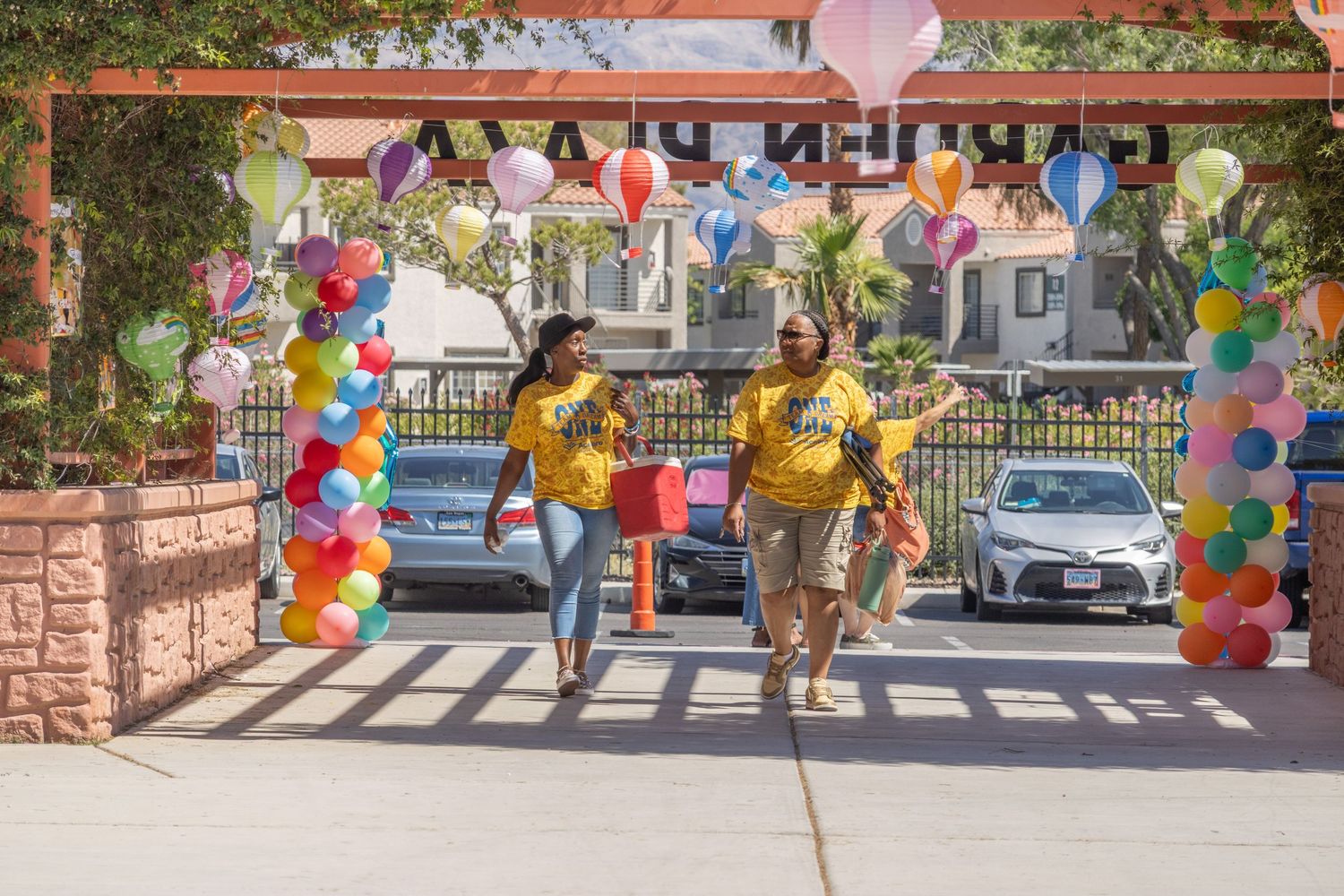 Outdoor event setup with colorful balloon decorations and pathways under sunny skies.