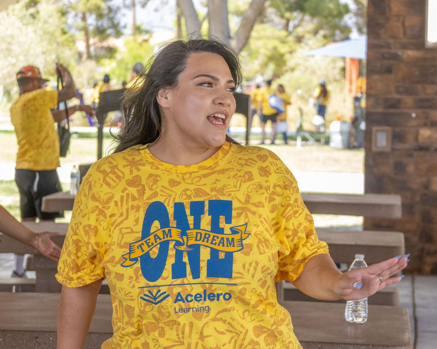 Team member in bright yellow branded shirt participating in outdoor activity.