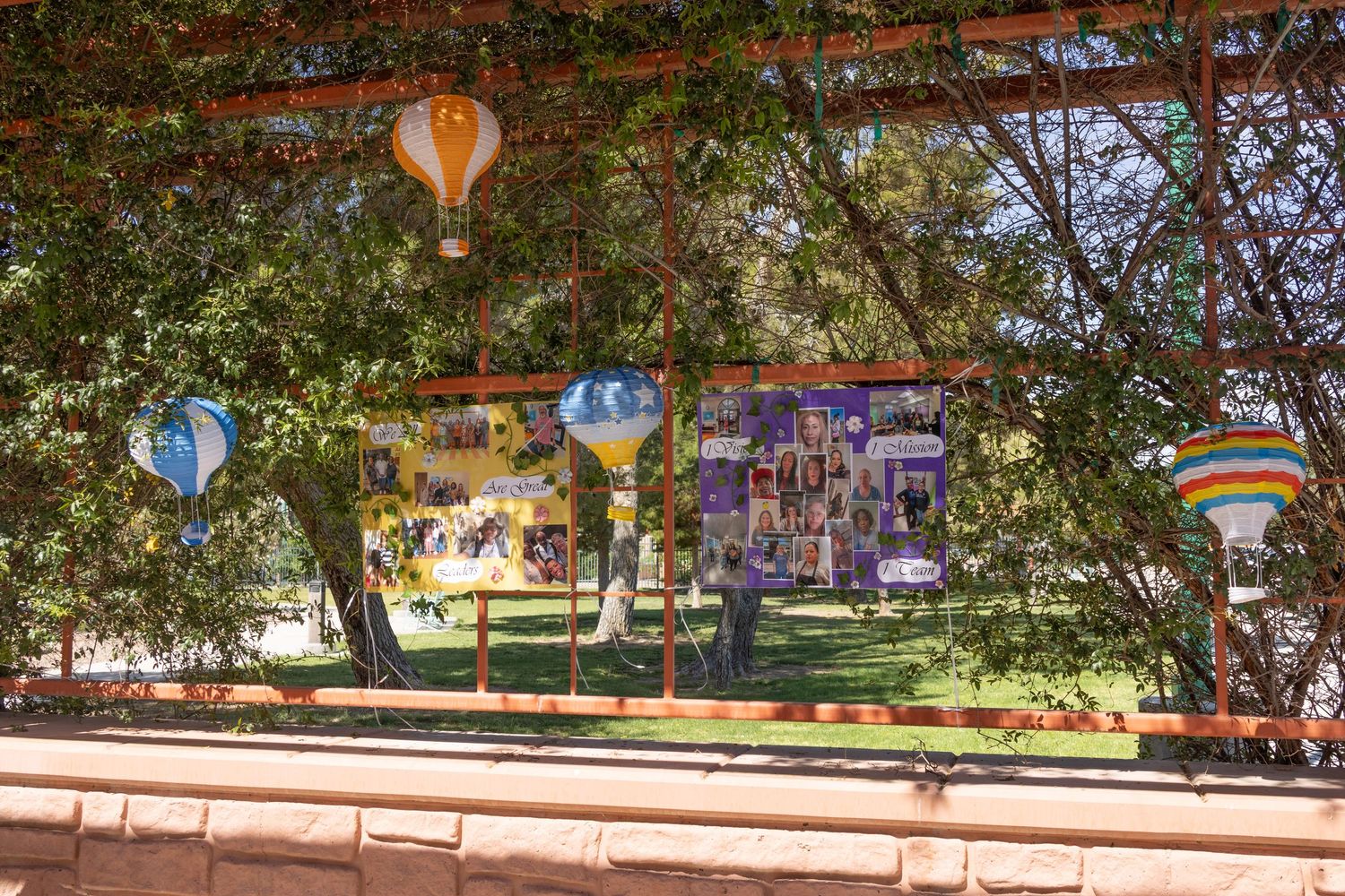 Outdoor plaza with red brick archways decorated with festive balloon arrangements.