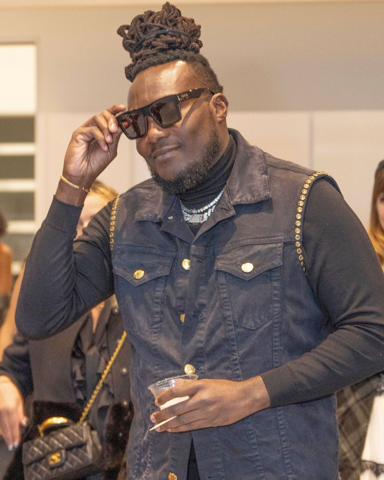 Person in denim jacket and sunglasses posing at an indoor event. Tunde Laleye