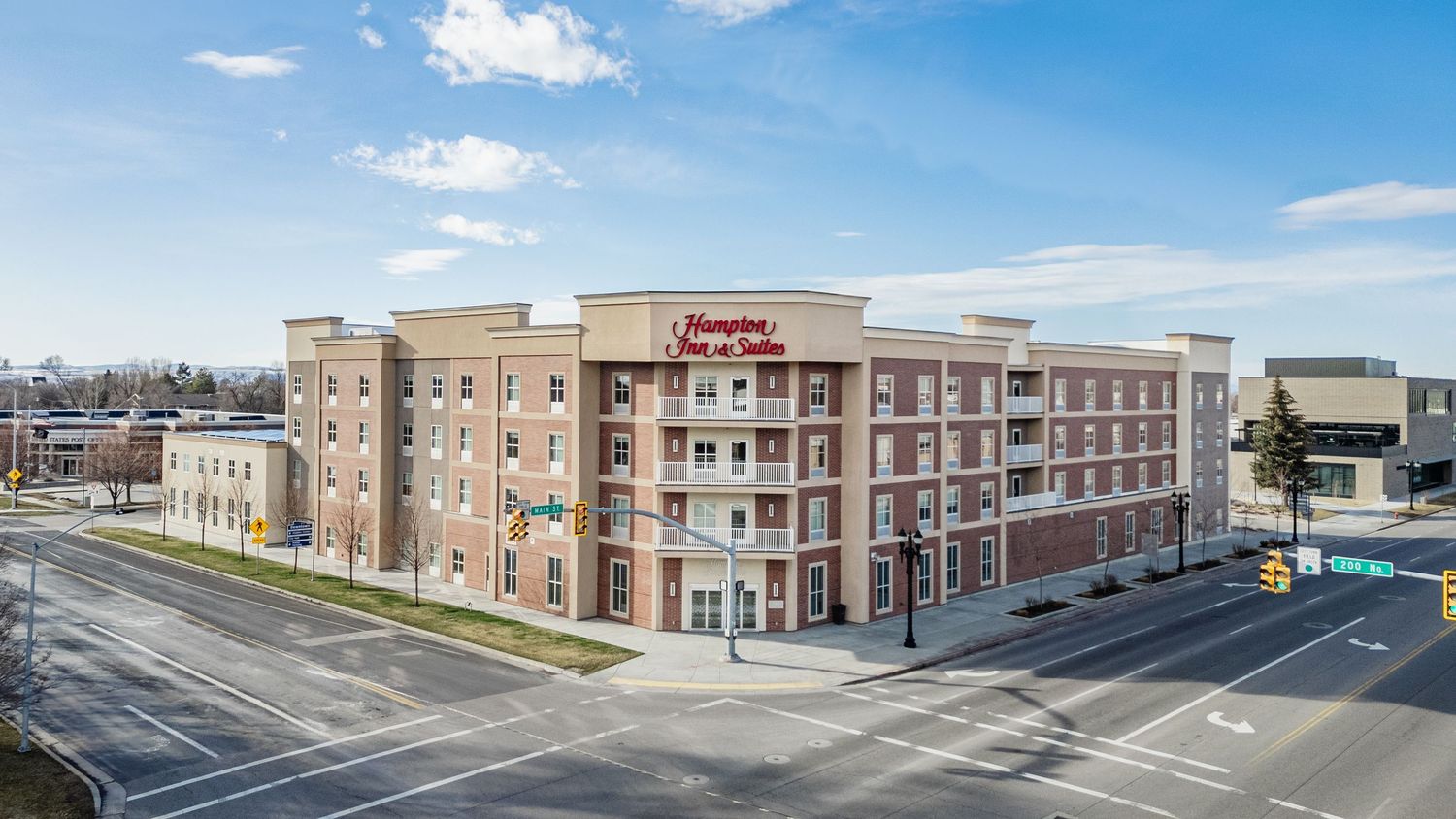 Panoramic view of commercial strip mall buildings with retail storefronts under blue sky.
