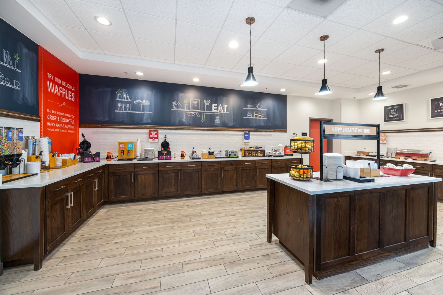 Long retail counter with dark wood cabinetry and red signage in modern commercial space.