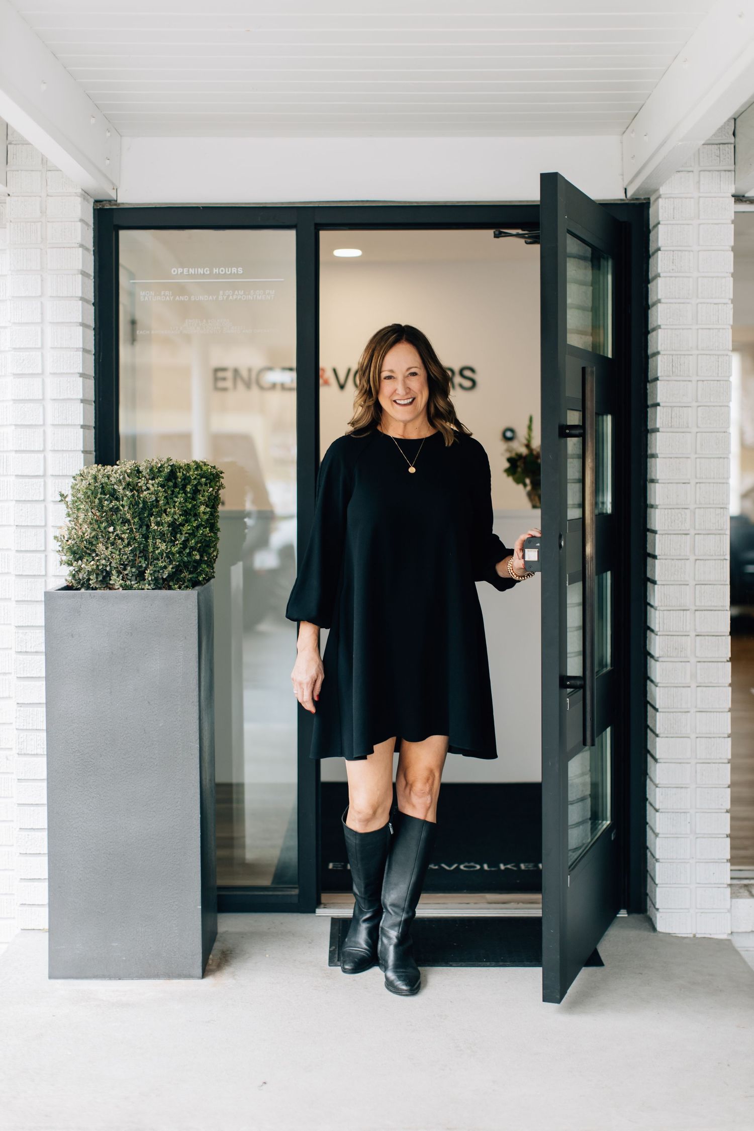 Modern office entrance with white brick exterior and glass doors.