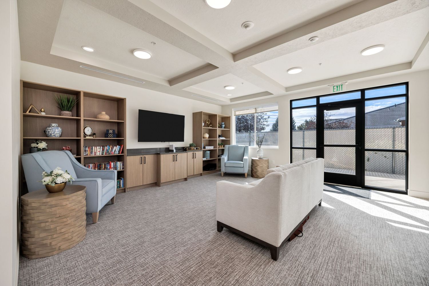 Modern office space with cathedral ceiling, recessed lighting, and large windows.