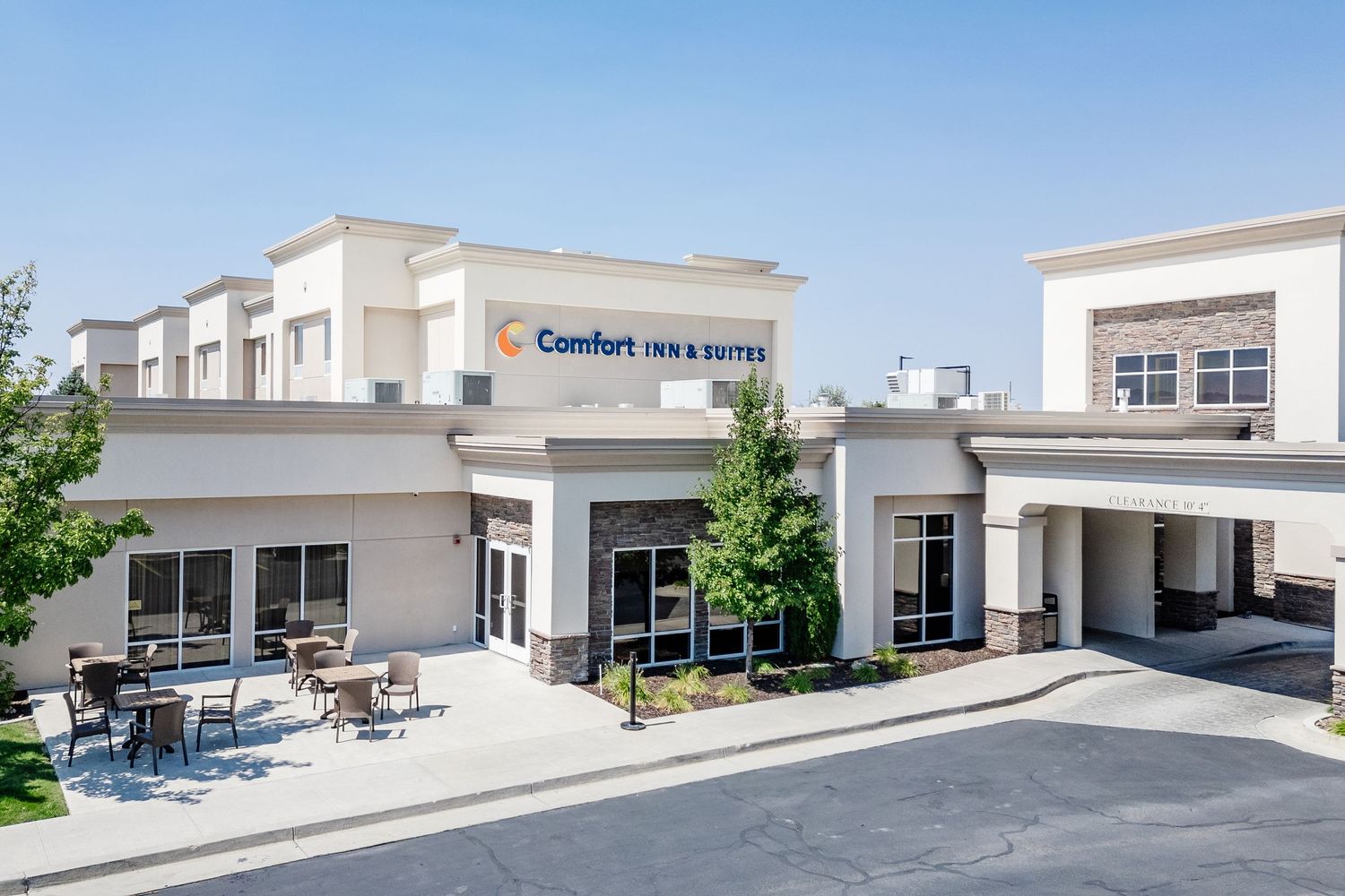 Modern commercial building exterior with loading docks and clean architectural lines against blue sky.