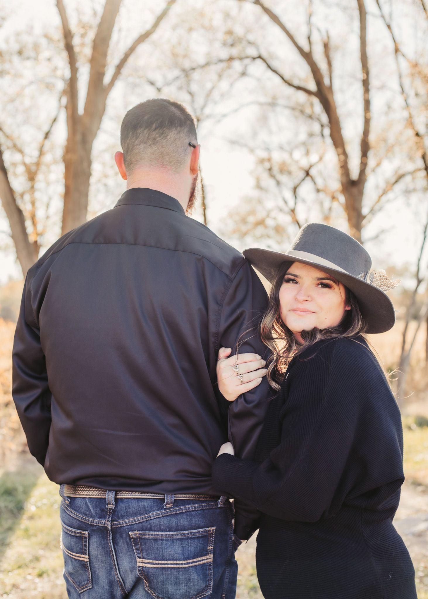 Couple embraces in matching navy outfits during autumn outdoor photoshoot.