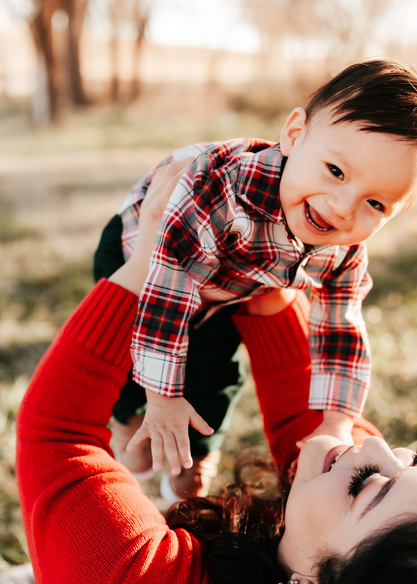 Playful parent-child moment captured during outdoor photoshoot.