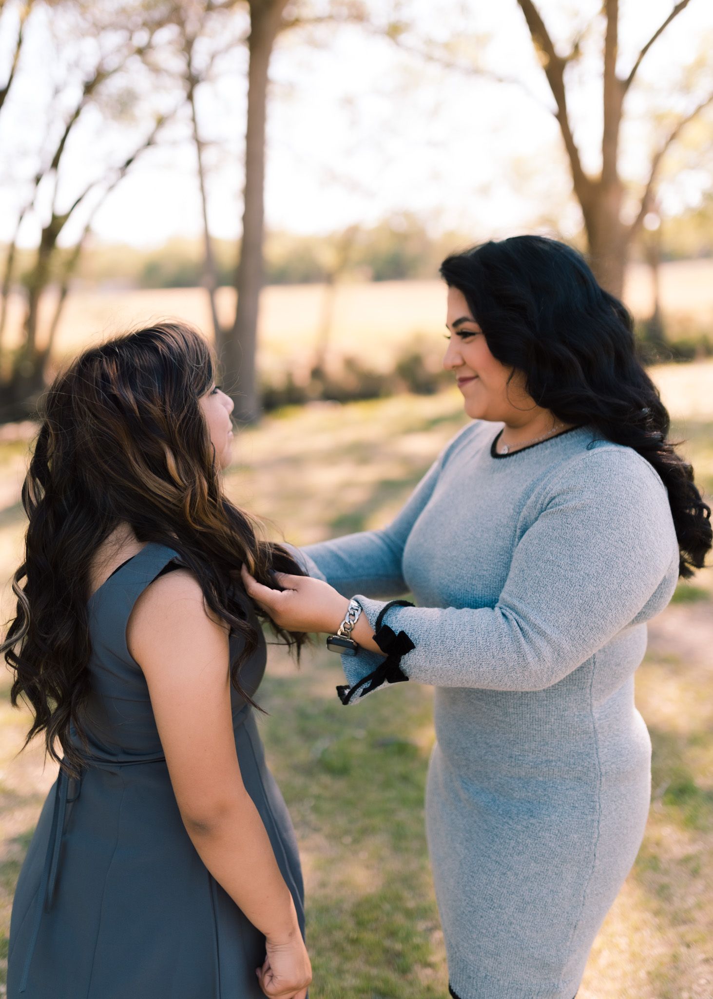 Two women having an intimate conversation outdoors in a natural setting during golden hour.