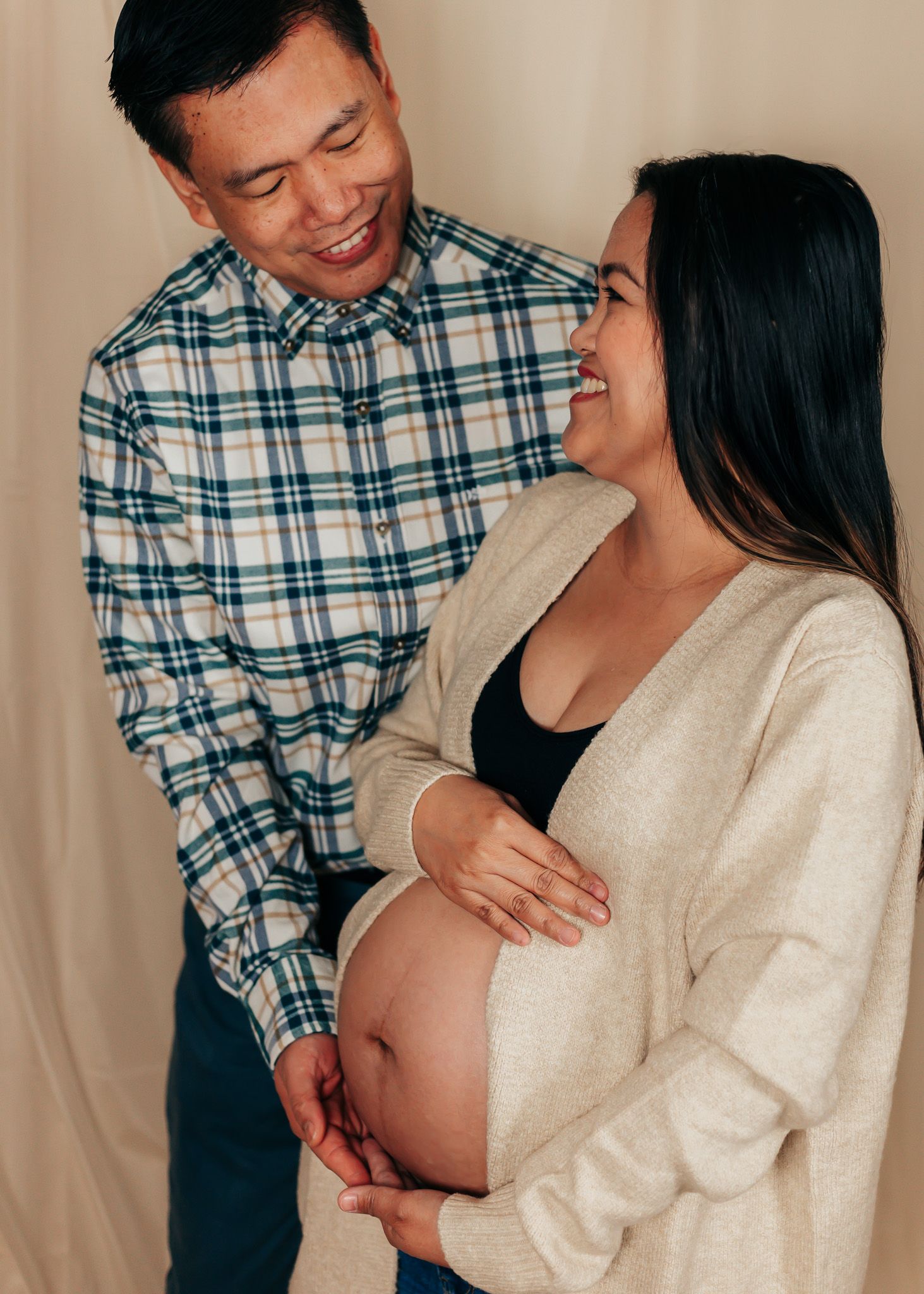 Intimate maternity photos showing tender moments between expectant parents.
