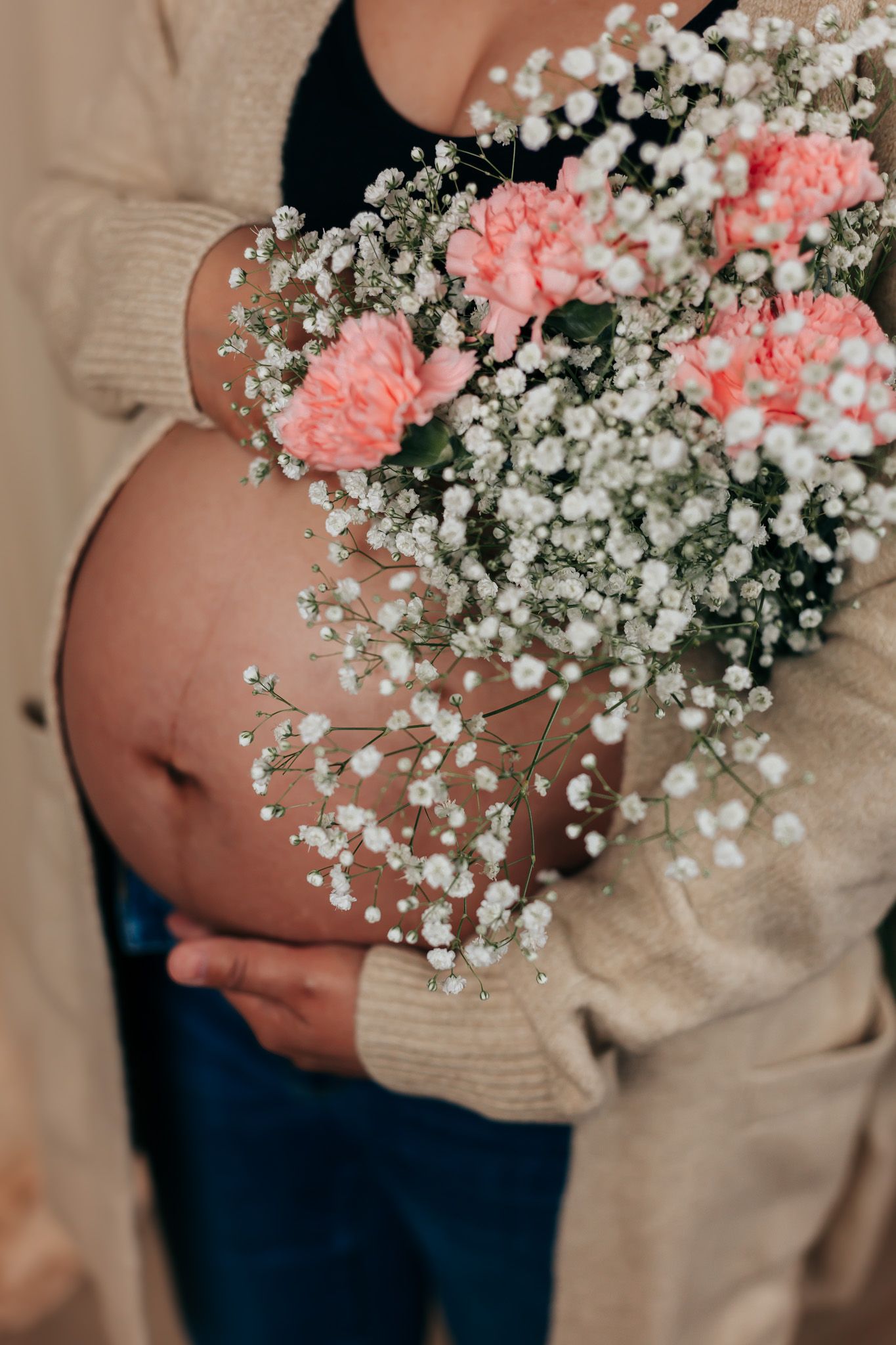 Pregnancy photos featuring baby's breath and pink carnation floral arrangements.