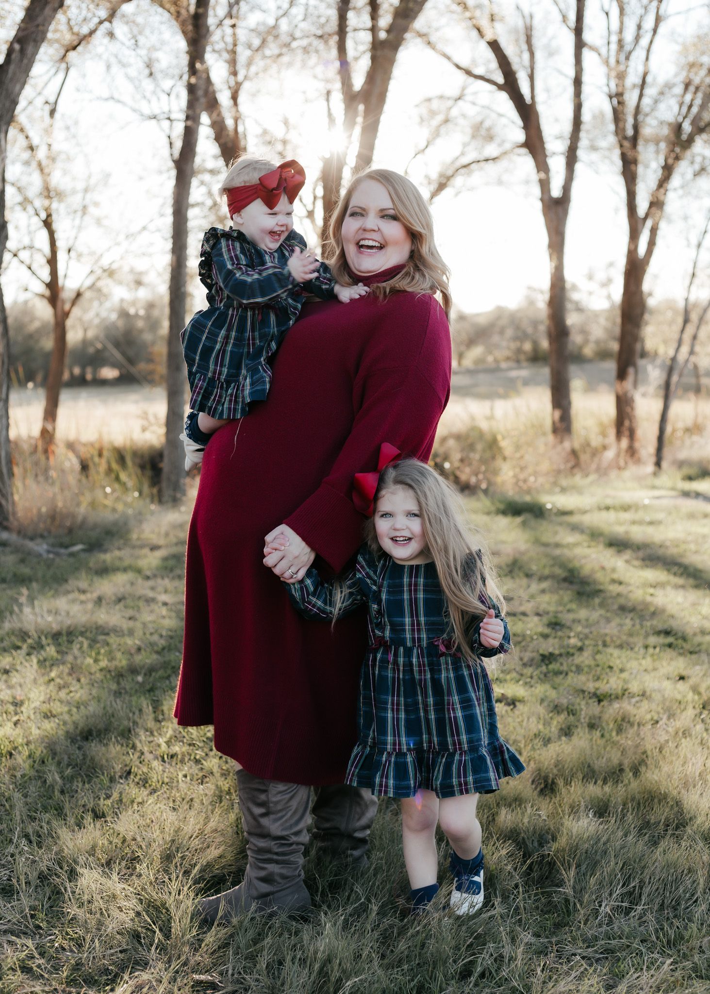 Mother and children in coordinated winter outfits posing together outdoors.