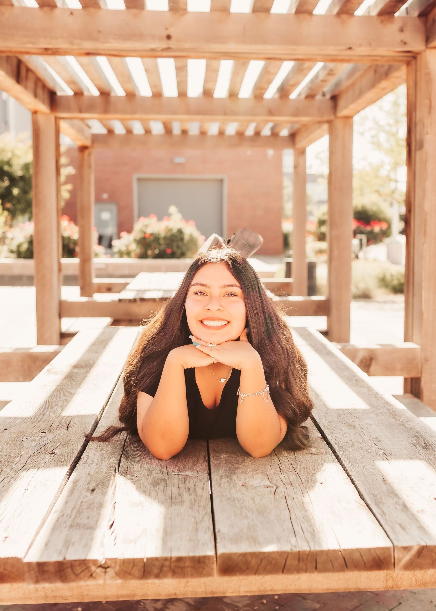 Portrait on wooden pergola bench in warm sunlit garden setting.