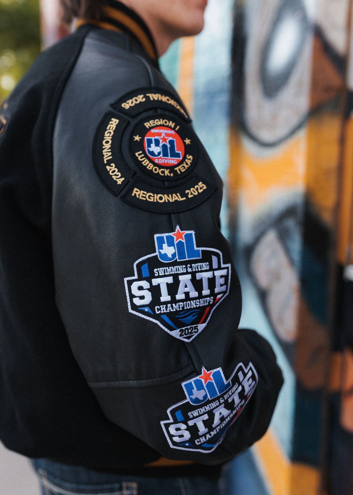 Black varsity jacket with CIL State Championships patches and Regional 2024 Lubbock Texas embroidered badge.