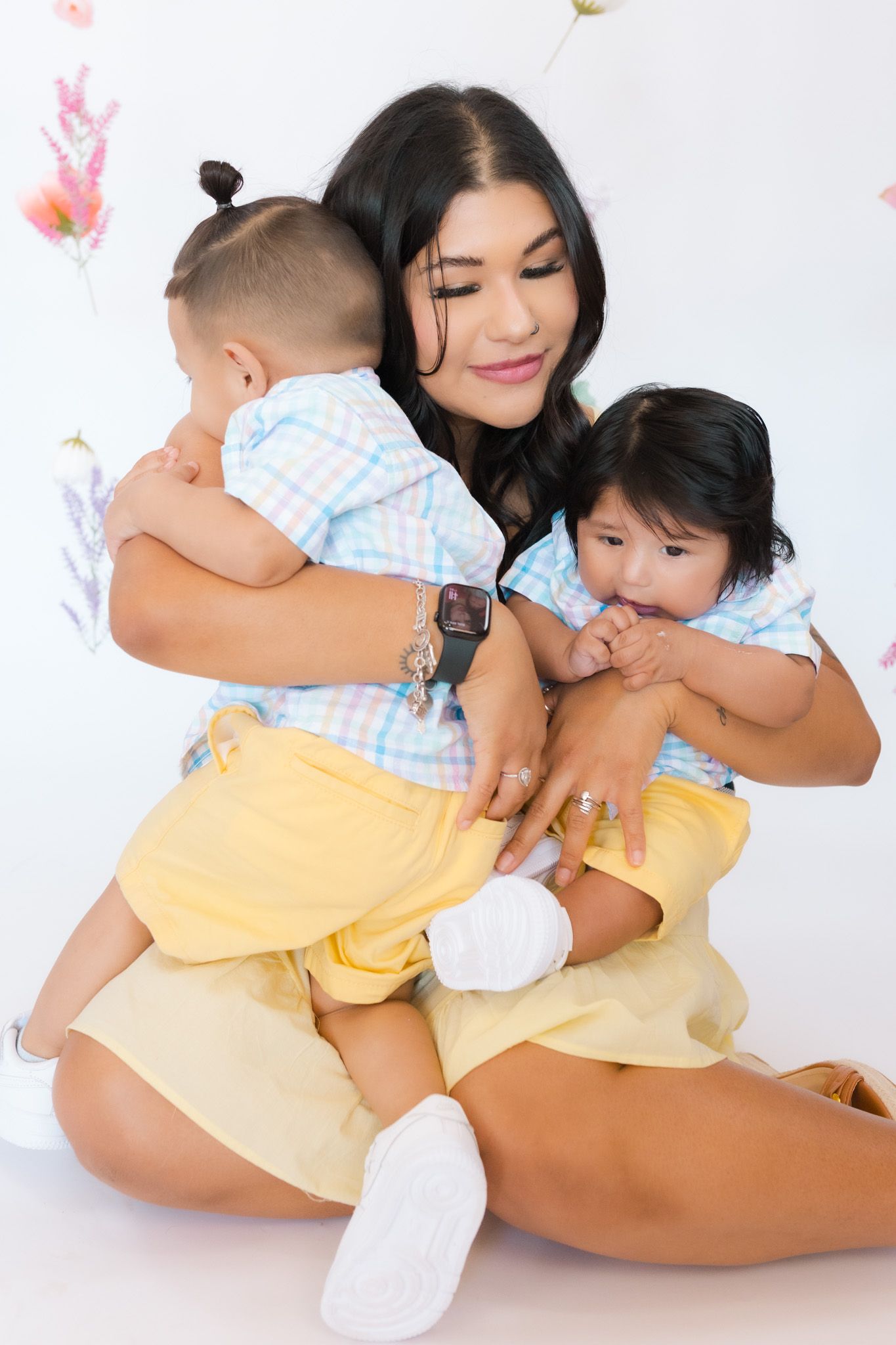 A heartwarming family photo with babies in coordinating yellow and blue checkered outfits.