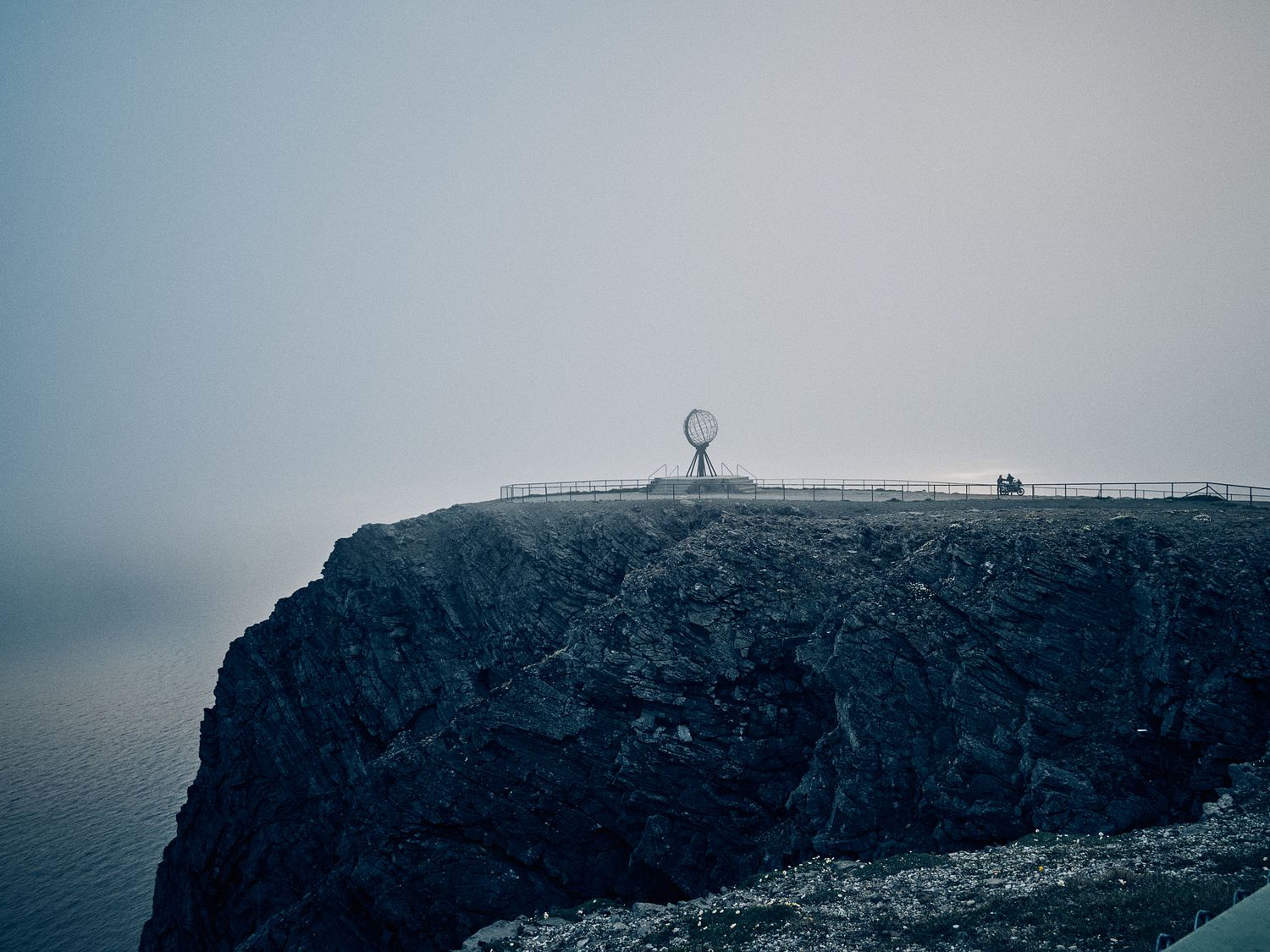 Moody coastline with rugged cliffs shrouded in fog and mist.