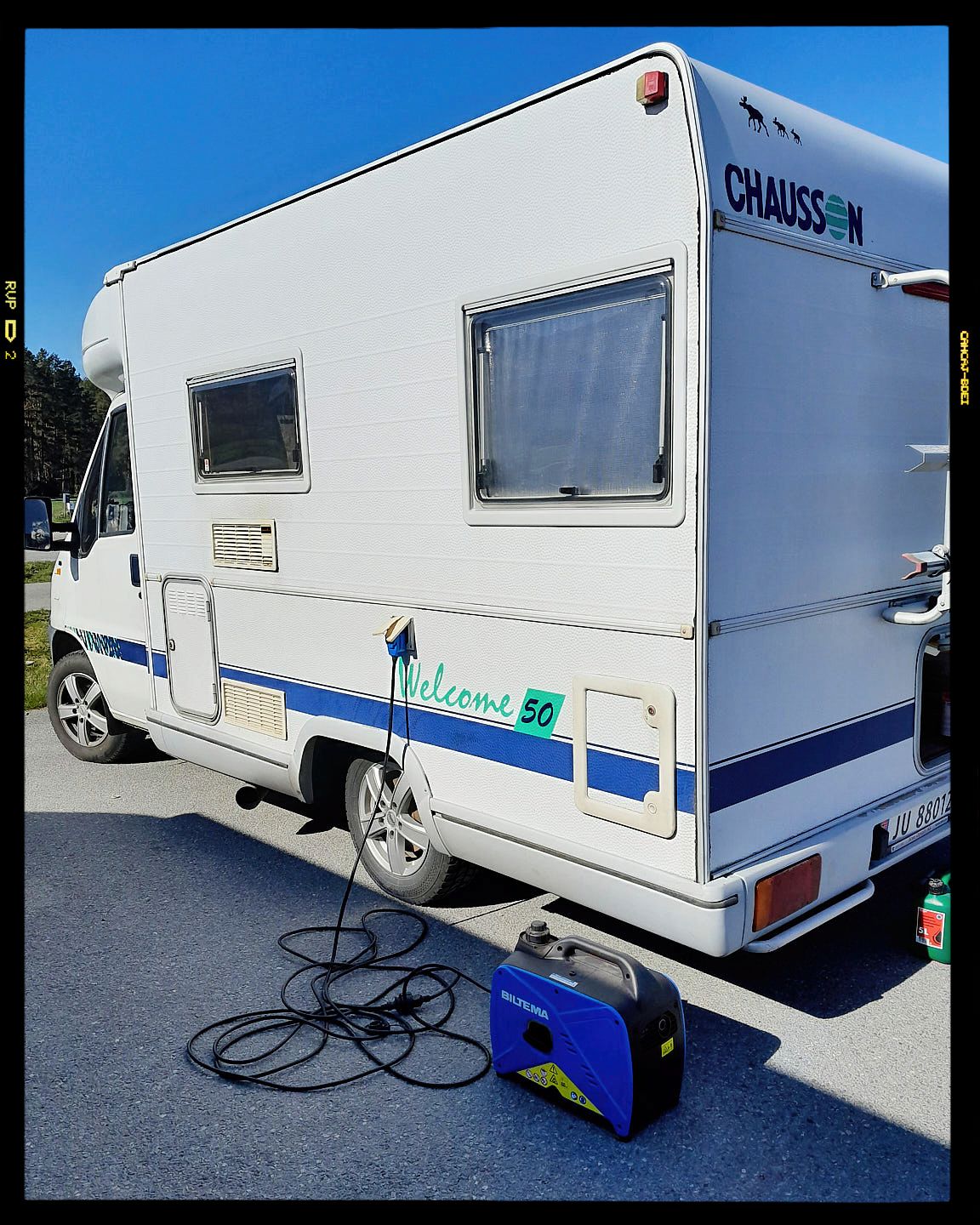 Multiple angles of a white travel trailer camper parked outdoors with power cables and stabilizing equipment visible.