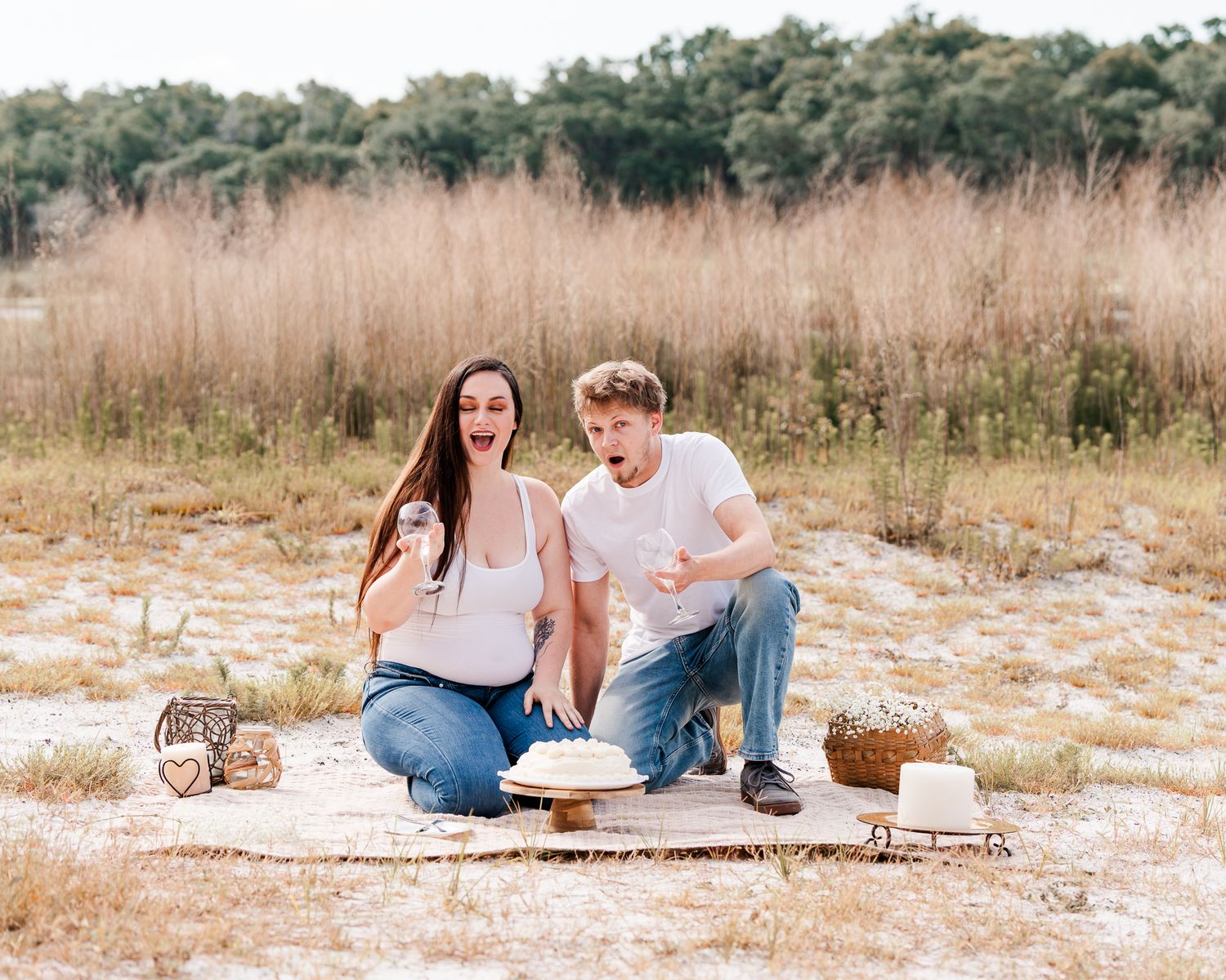 Couple relaxing together on picnic blanket in rustic field during golden hour.