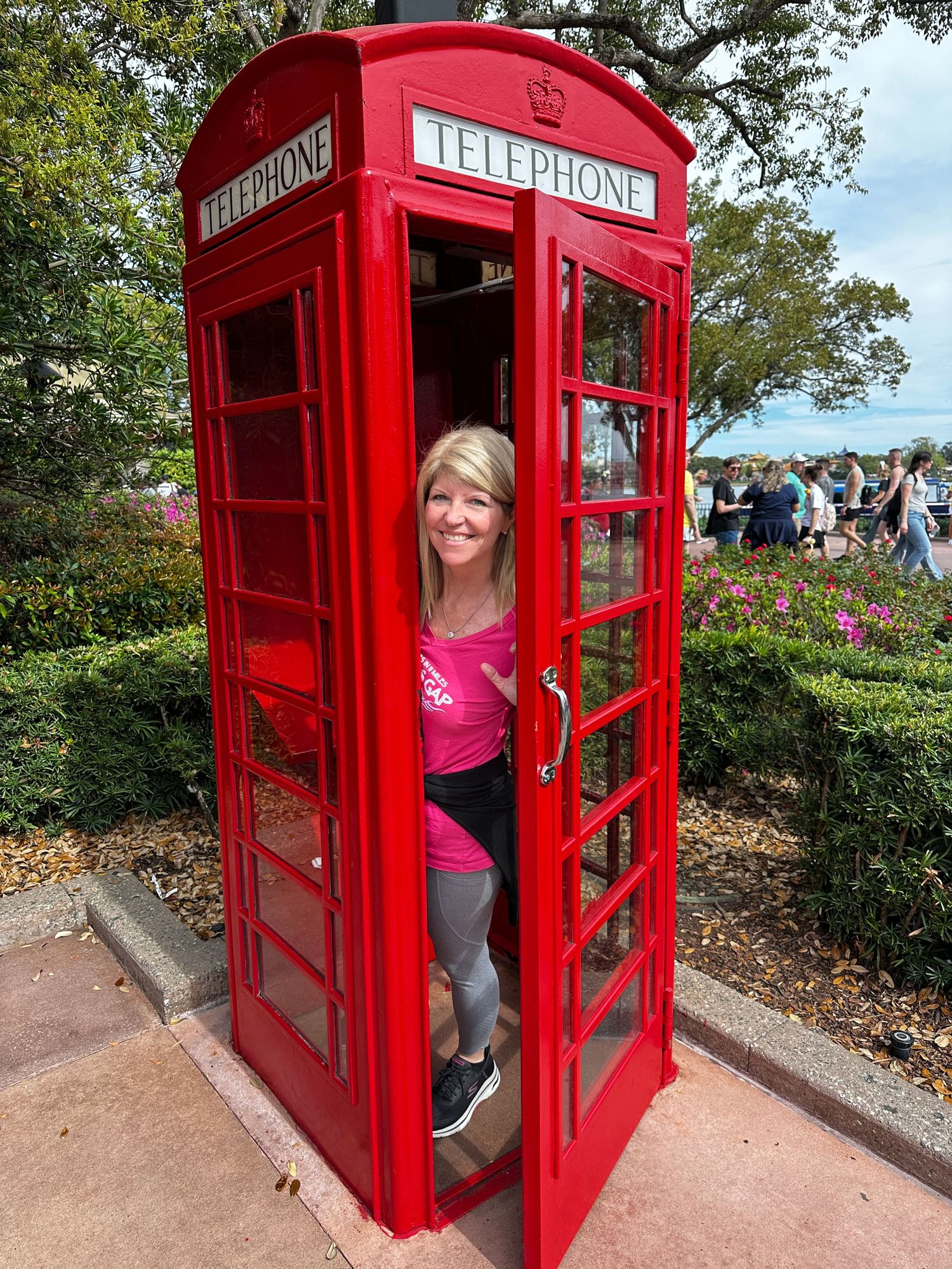 Kathy poses playfully inside an iconic red British telephone booth.