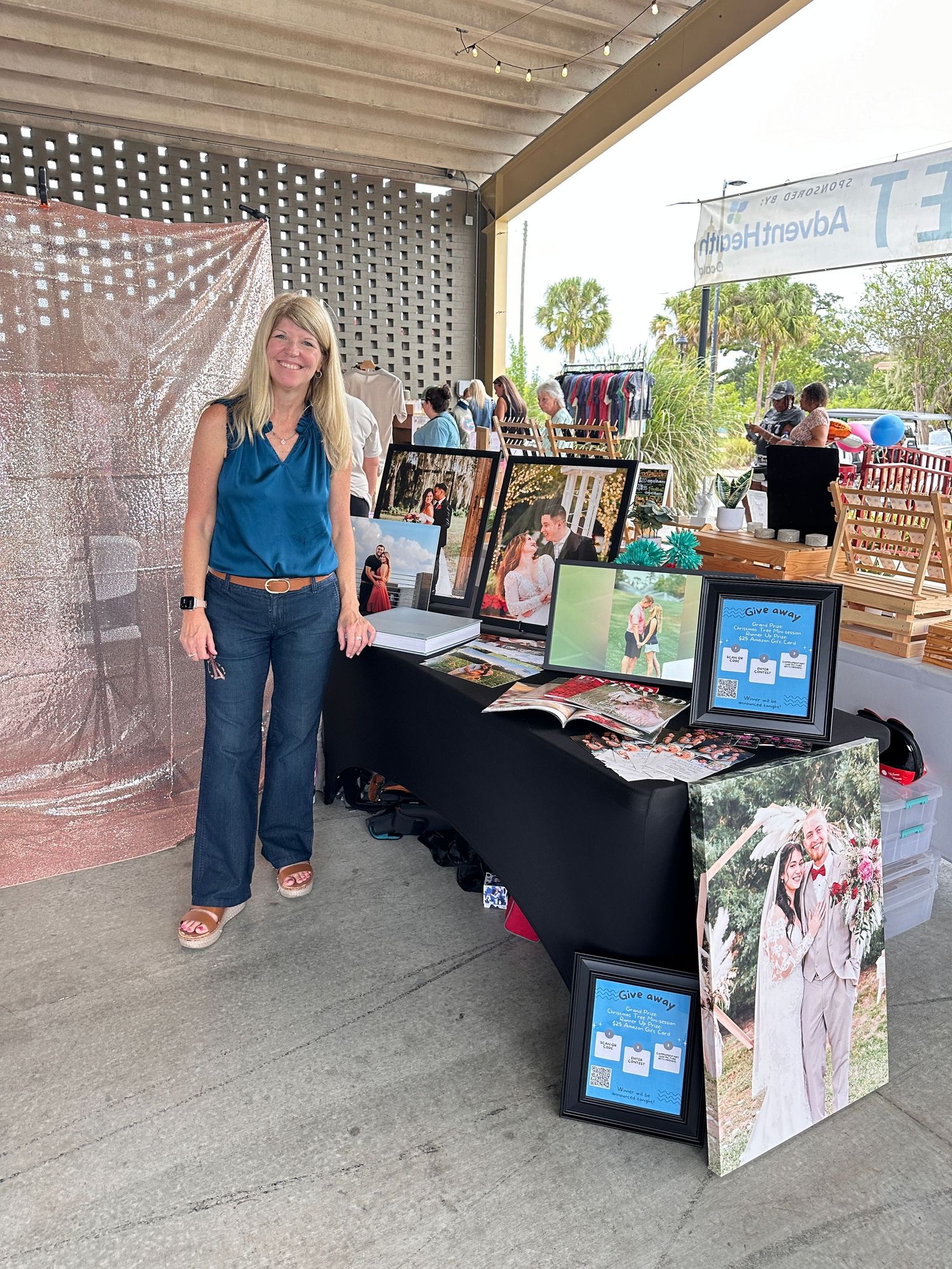 Kathy in front of her Photography vendor booth display with prints and portfolio materials.