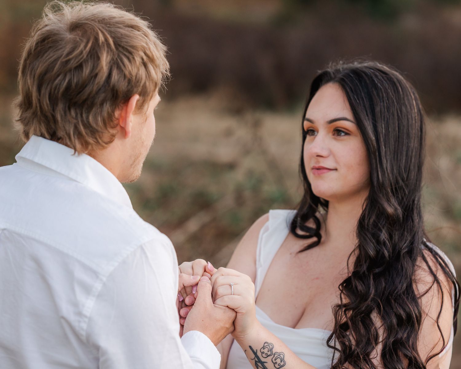 A romantic outdoor photoshoot captures intimate moments between a couple in white and black attire.