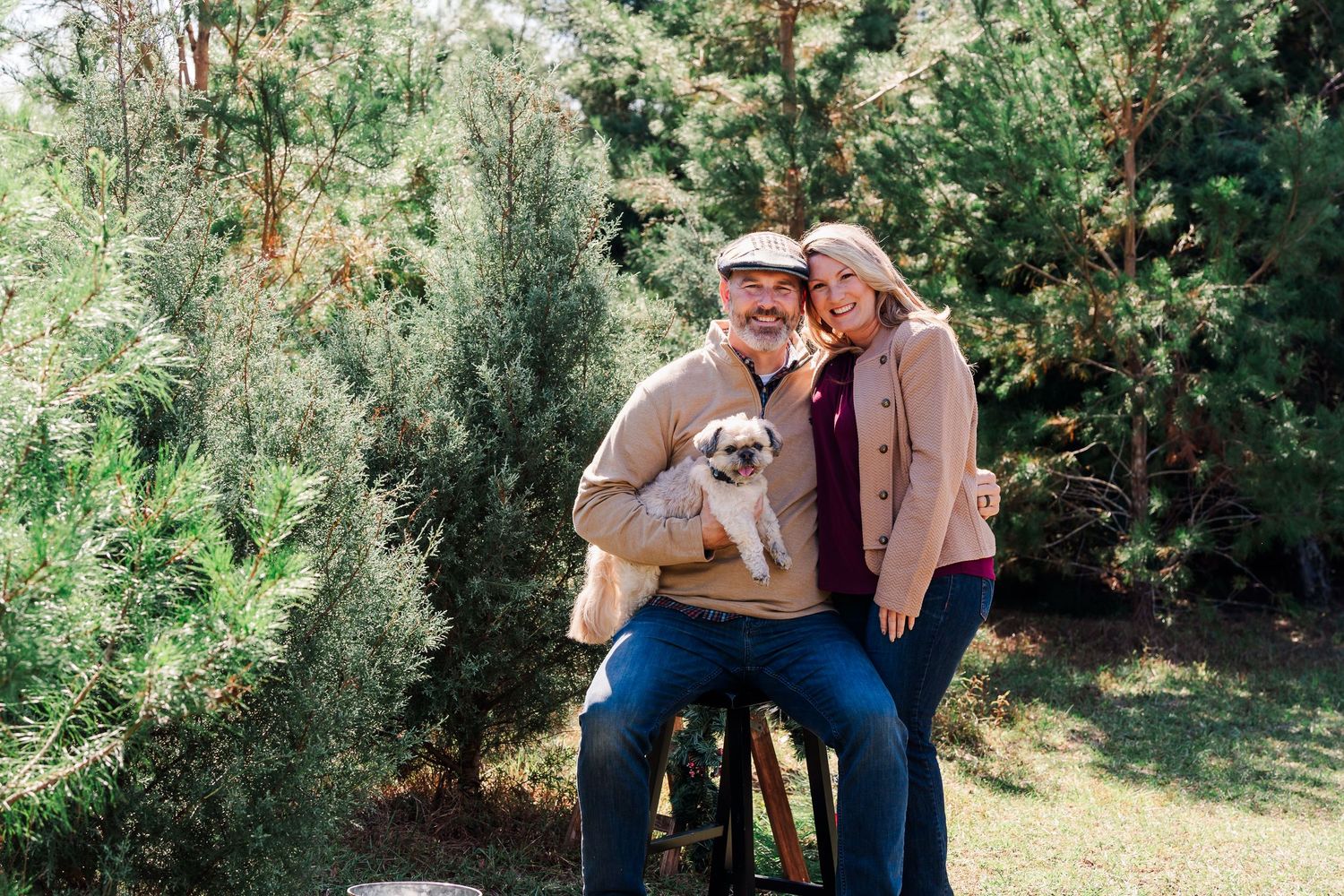 A couple shares tender moments in a sunlit garden setting during an outdoor photoshoot in nature.