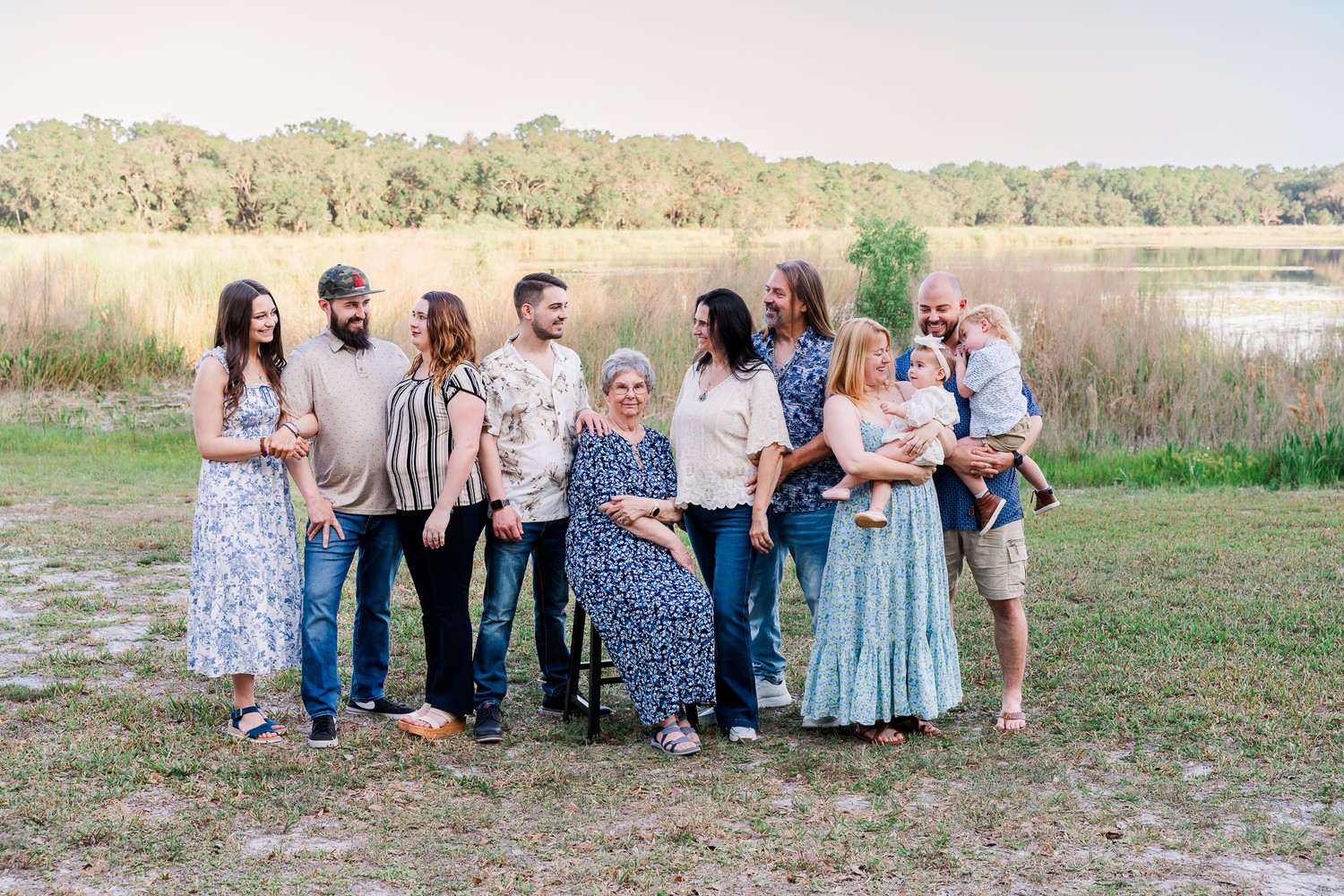 A group portrait session outdoors with people wearing coordinating blue and denim outfits on a sunny day.
