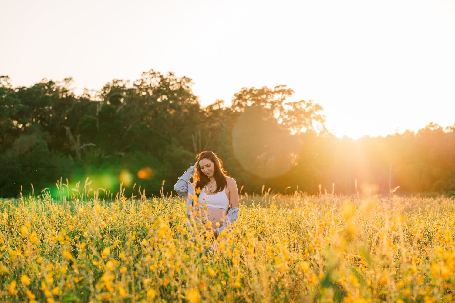 Golden sunlight illuminates a wildflower field during a romantic photoshoot.