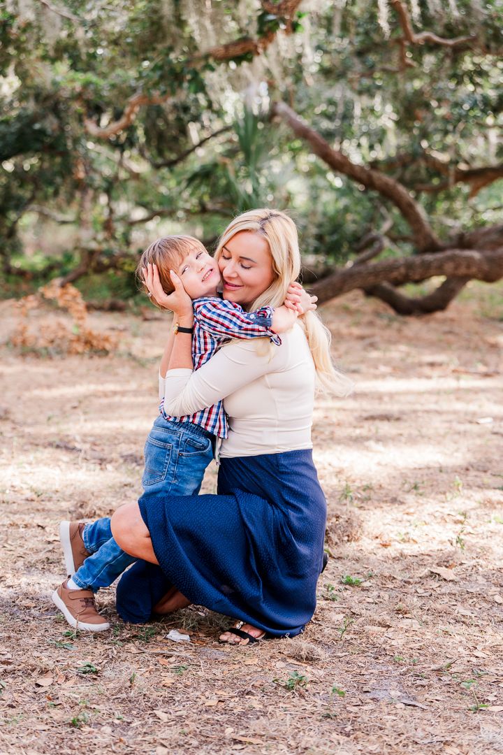 Relaxed outdoor portraits against a rustic tree backdrop with natural lighting.