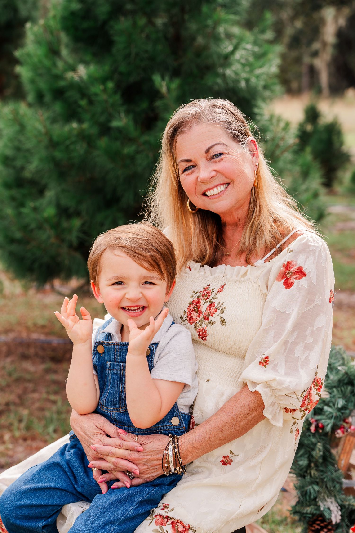 A heartwarming family photo session in a natural outdoor setting with evergreen trees in the background.