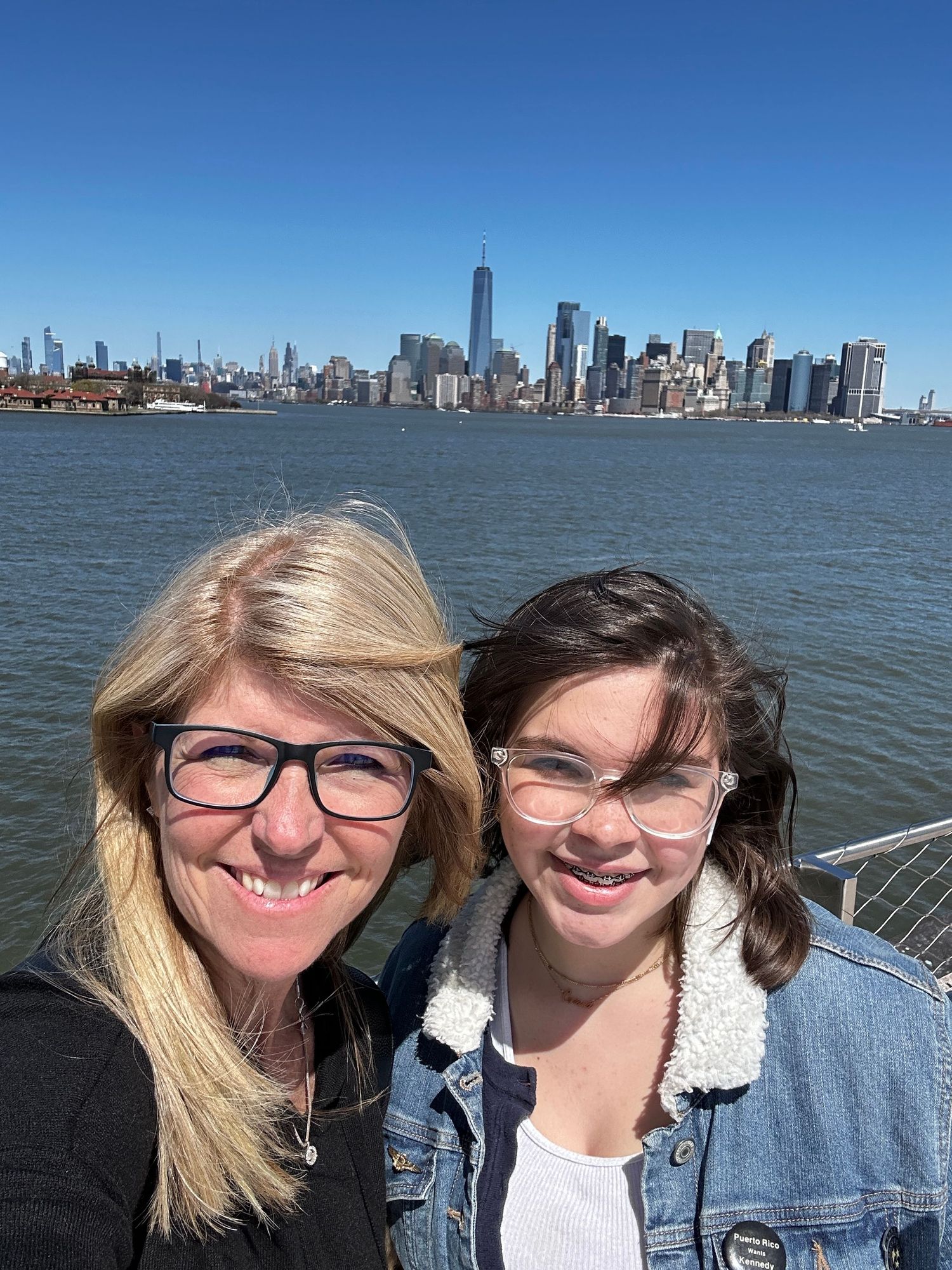 NYC skyline view from the water with One World Trade Center prominent in background.