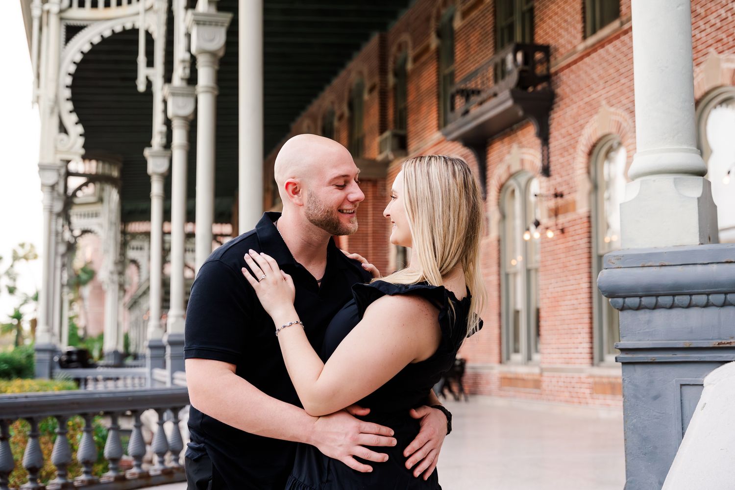 A romantic couple embraces under a beautiful brick archway during their wedding photo session.