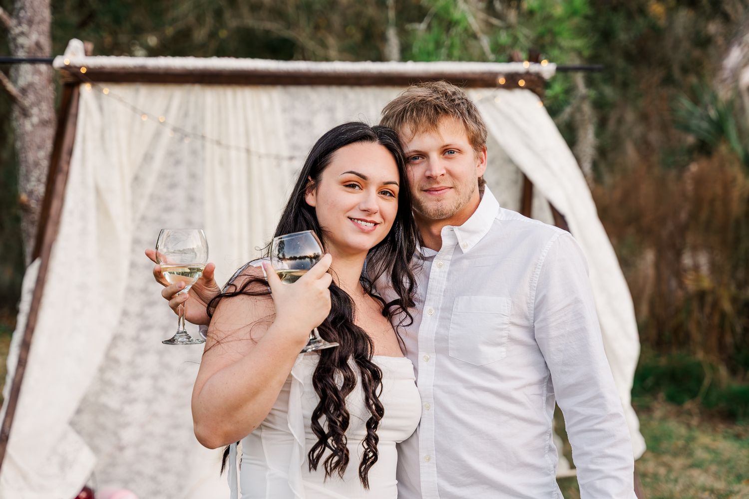 A wedding couple poses together in a garden setting for romantic outdoor portraits.