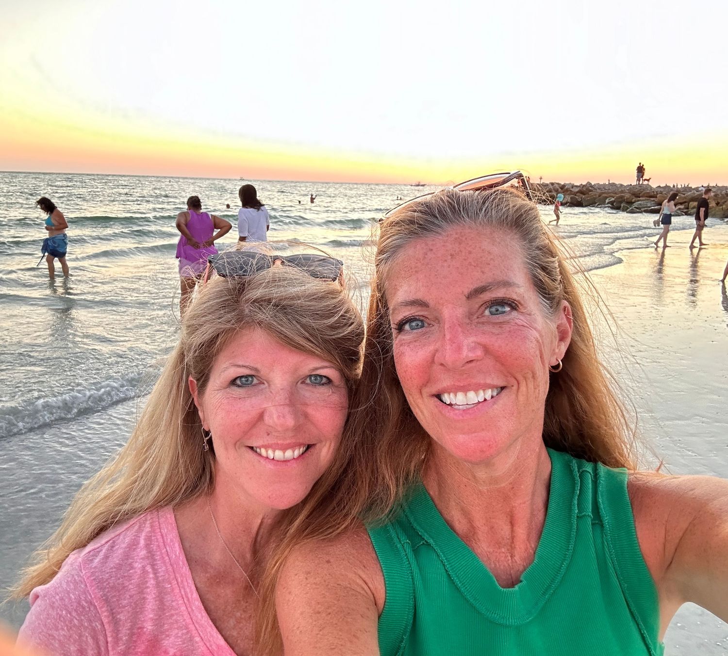 Cousins taking sunset beach selfies during golden hour.